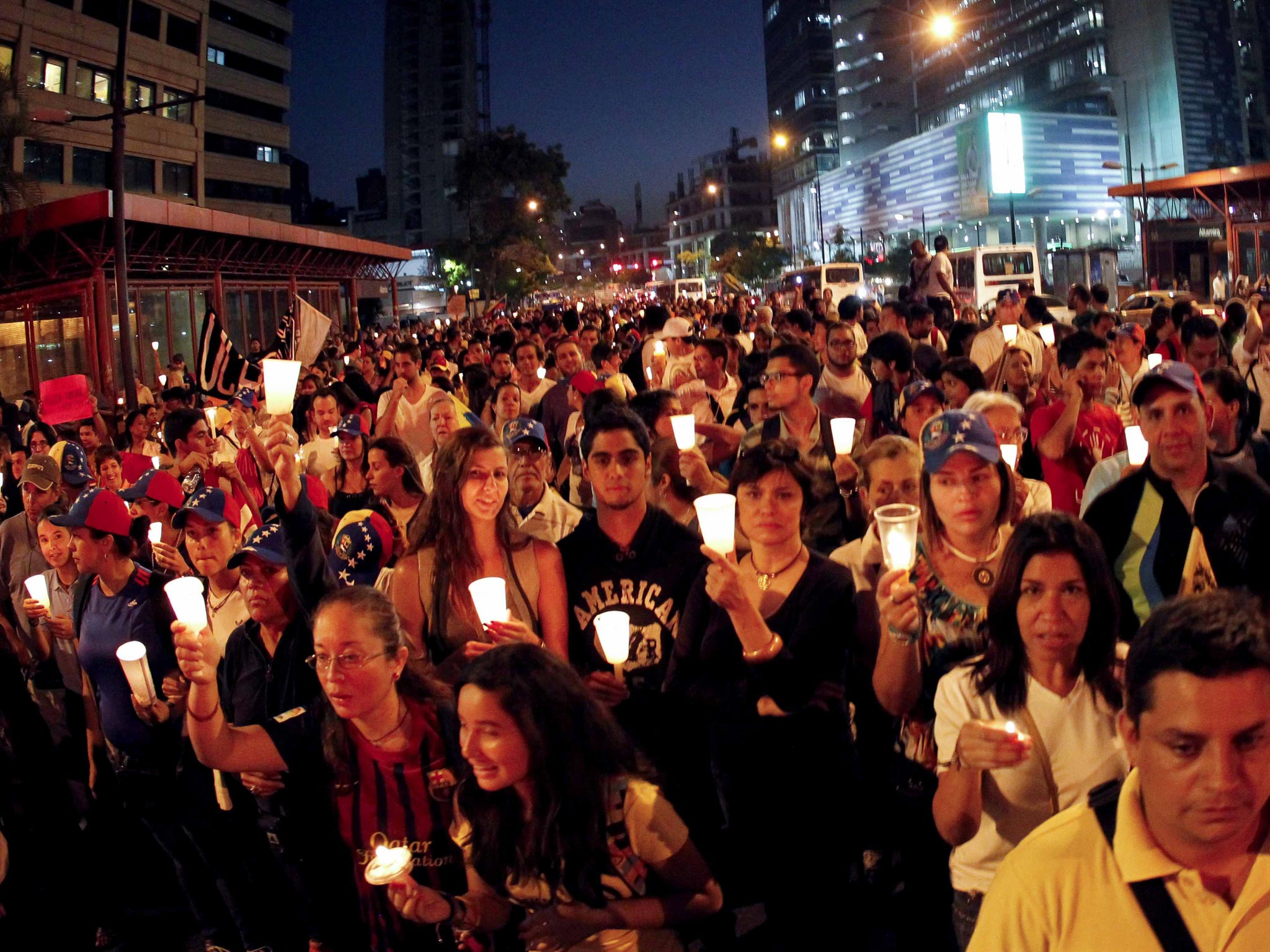 Opposition supporters hold candles as they take part in a rally against Nicolas Maduro's government in Caracas