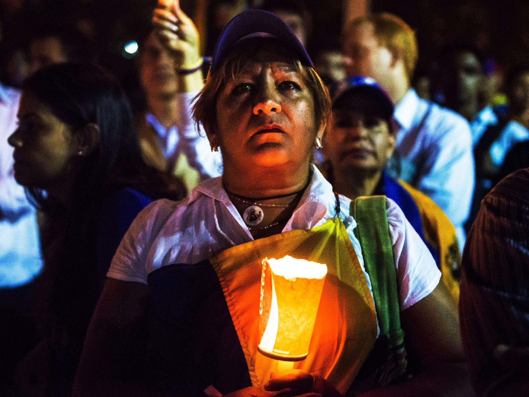 A woman holds a candle as she protests against Venenzuelan President Nicolas Maduro in Caracas