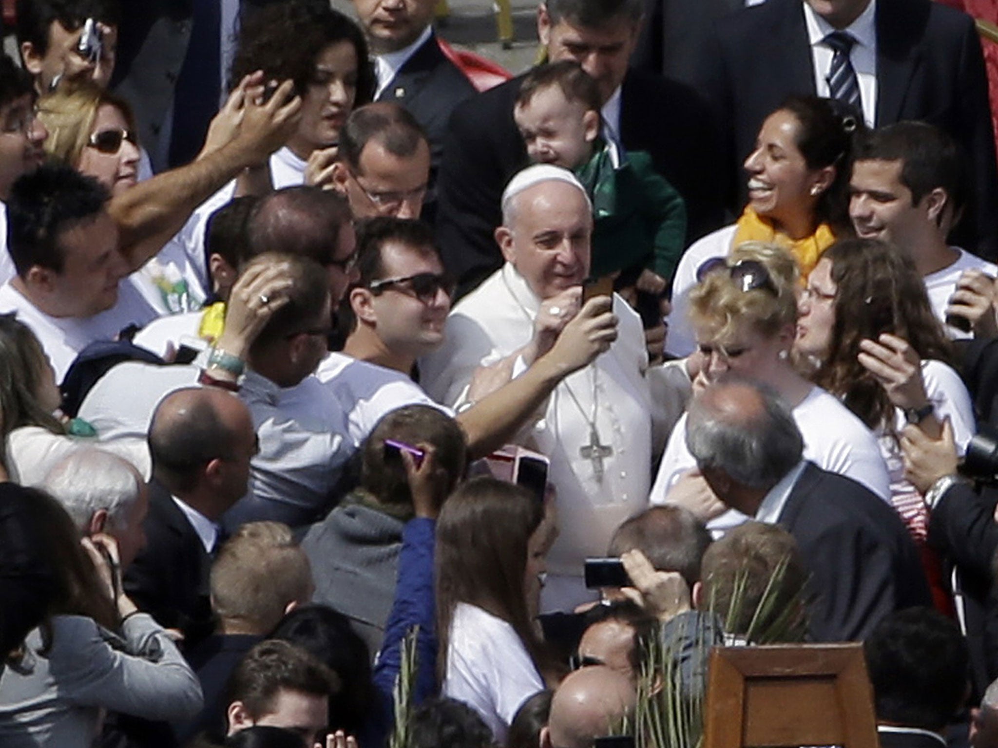 Pope Francis poses for pictures at the end of a Palm Sunday service in St Peter's Square