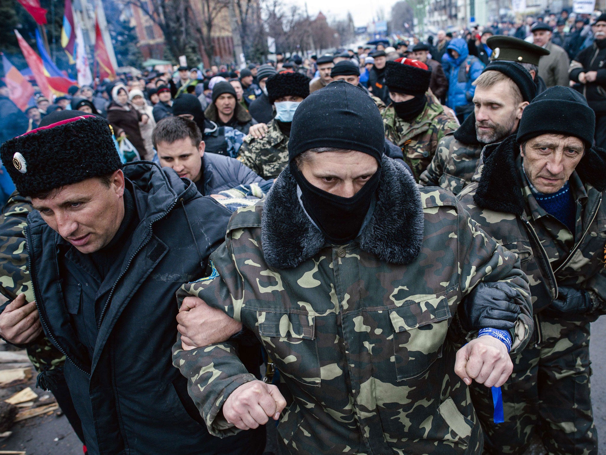 Pro-Russian activists escort a man (unseen) who they say is a provocateur outside the secret service building in the eastern Ukrainian city of Lugansk