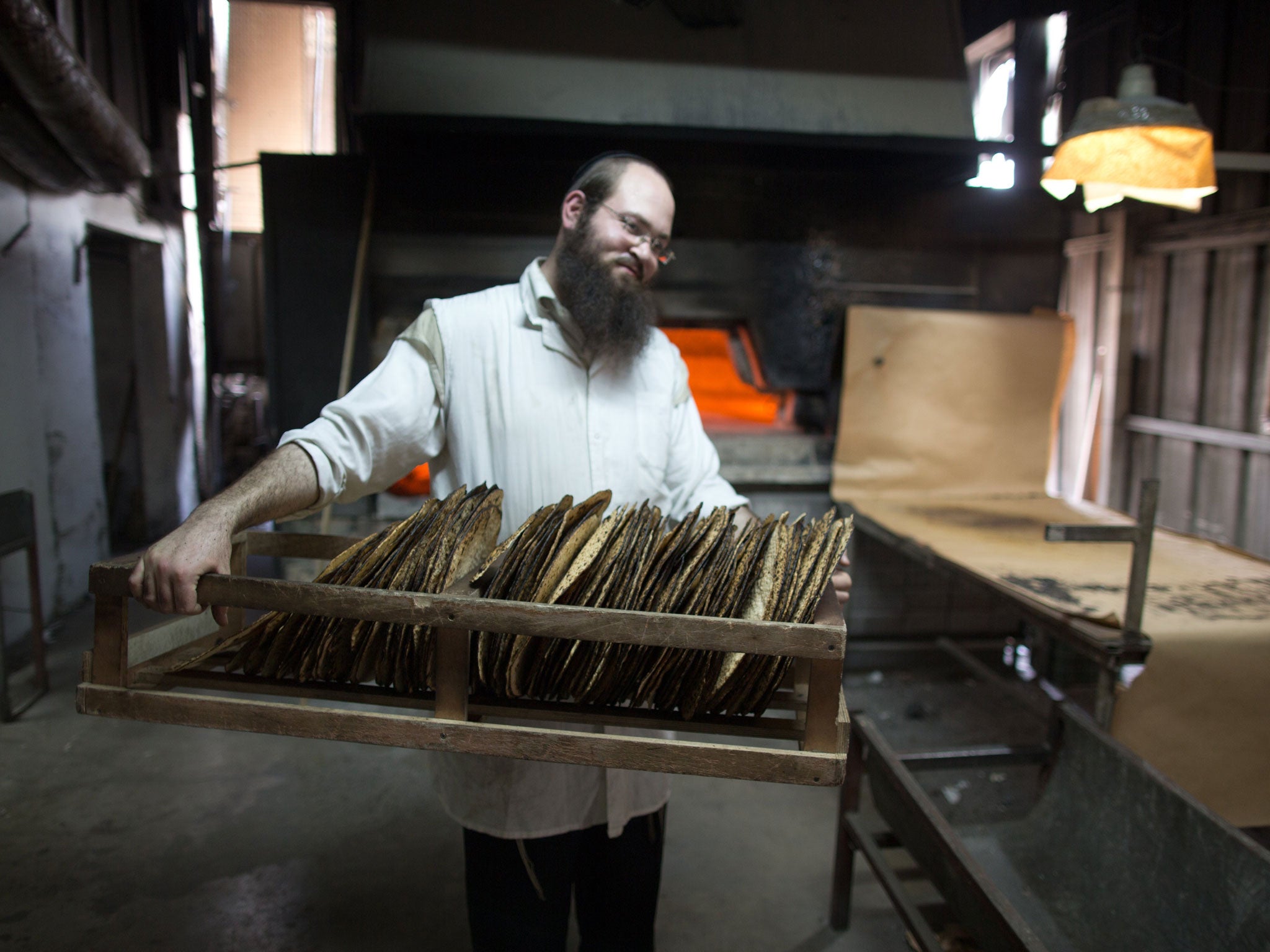 A Jewish man carries baked Matzoth on 24 March in southern Israeli village of Komemiyut near the Israeli town of Kiryat Gat.