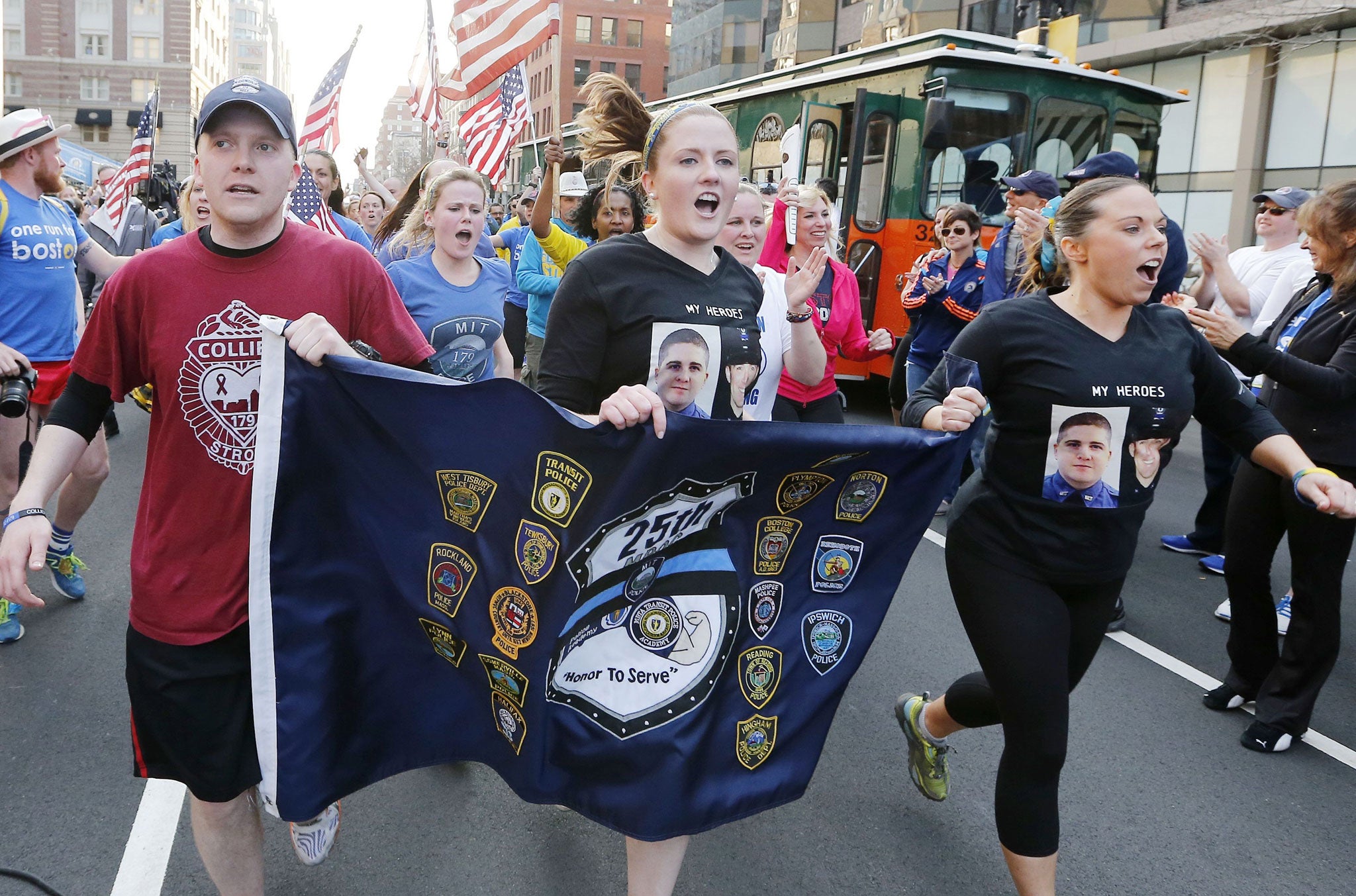 Supporters of slain MIT police officer Sean Collier carry a banner to the finish line of the Boston Marathon