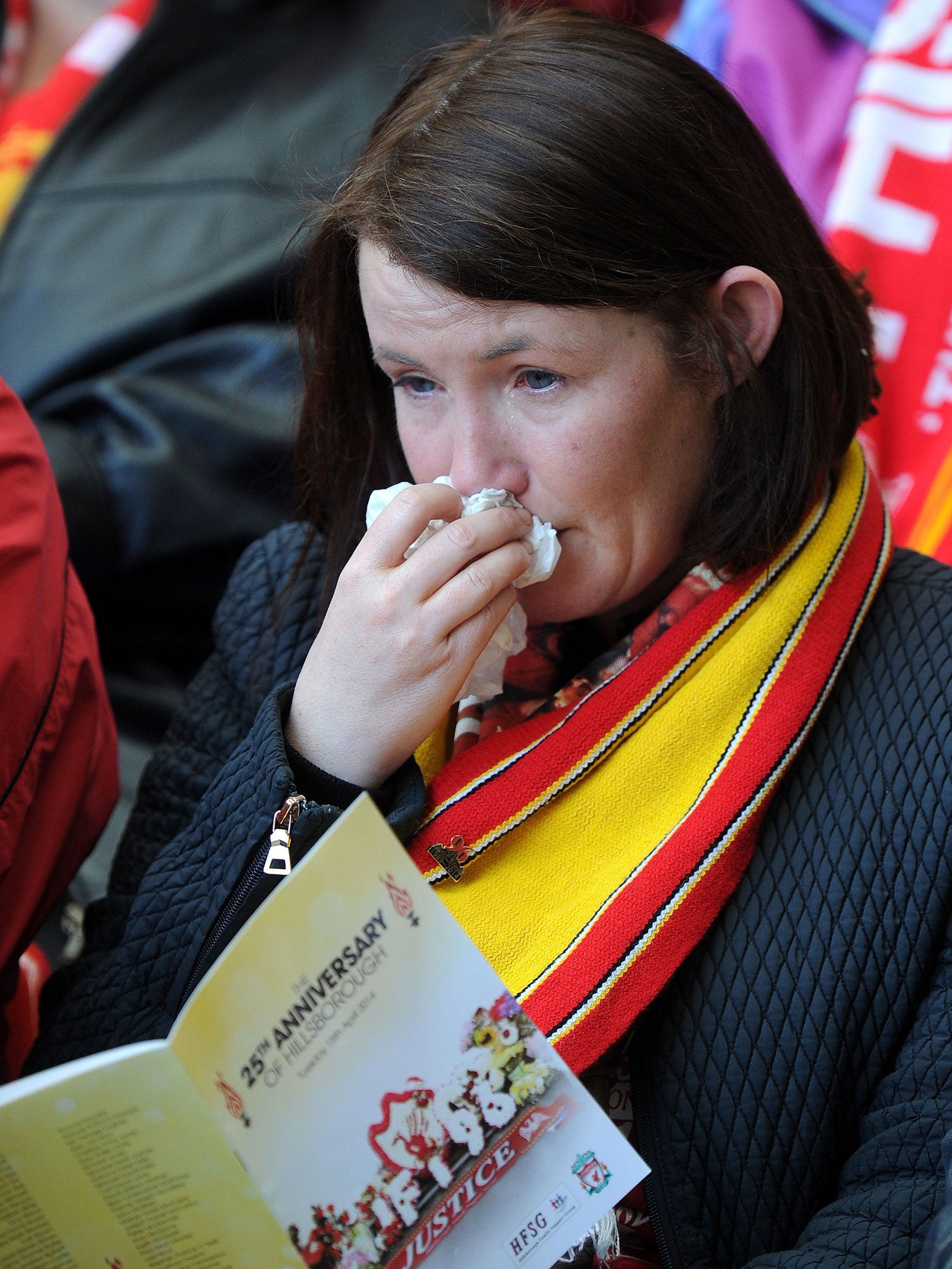A Liverpool fan wipes away tears during the Hillsborough 25th Anniversary Memorial Service at Anfield Stadium in Liverpool