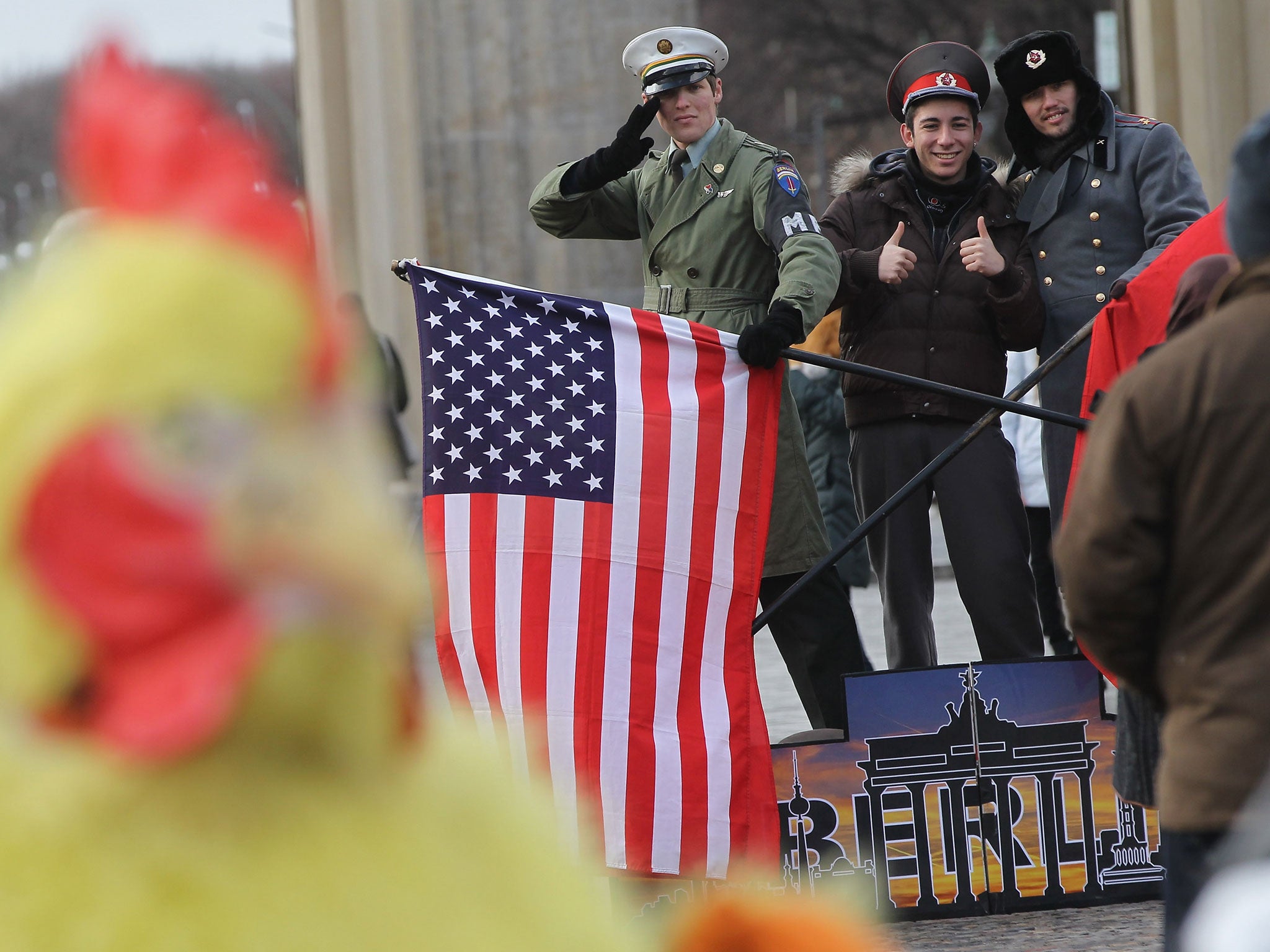 An animal activist dressed as a chicken competes with actors dressed in Cold War uniforms for the attention of tourists at Pariser Platz near the Brandenburg Gate.
