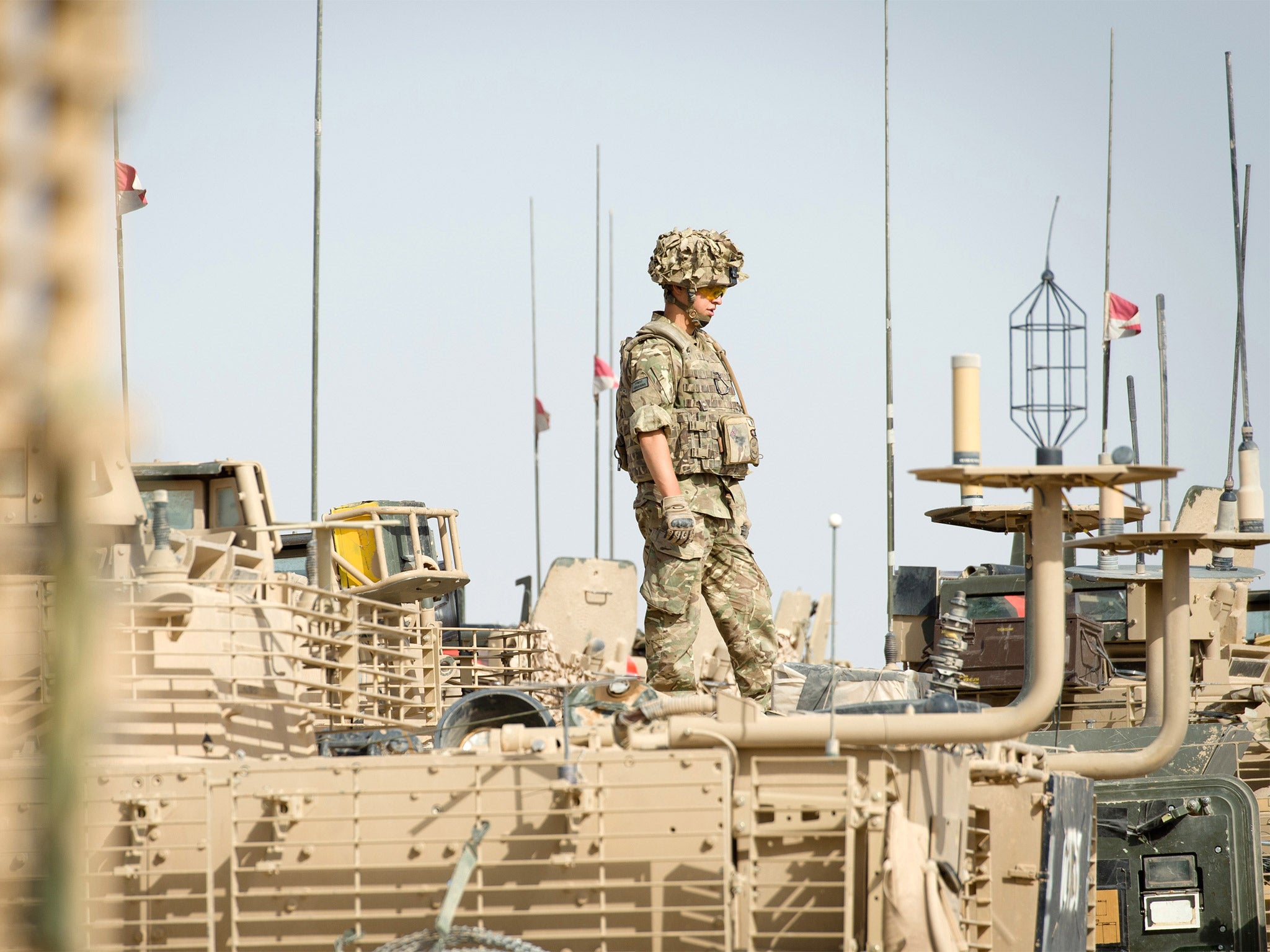 A British soldier stands on top of an armoured vehicle in Camp Bastion