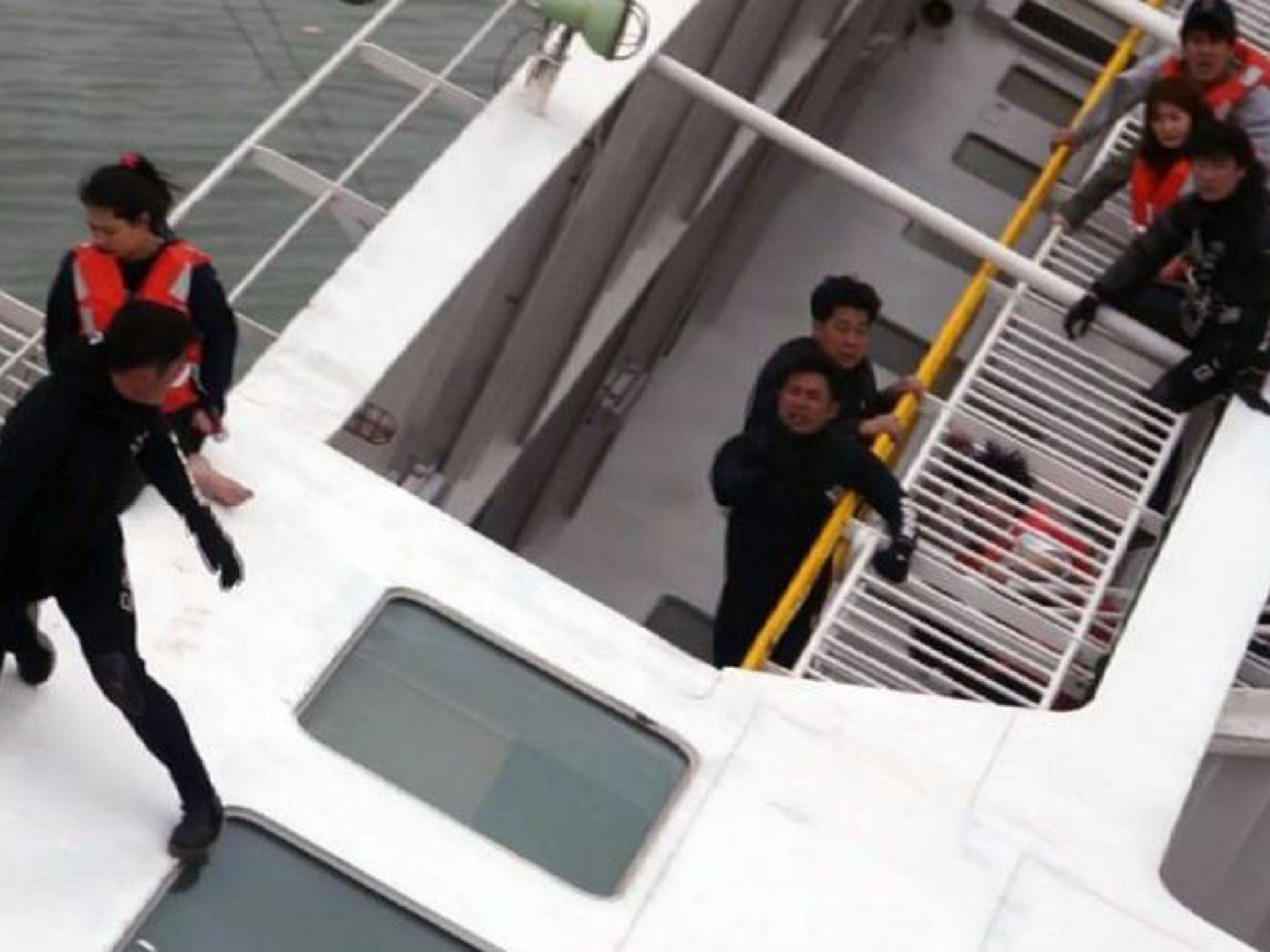 South Korea Coast Guard members rescuing some of the 477 passengers and crew aboard a South Korean ferry capsizing on its way to Jeju island from Incheon.