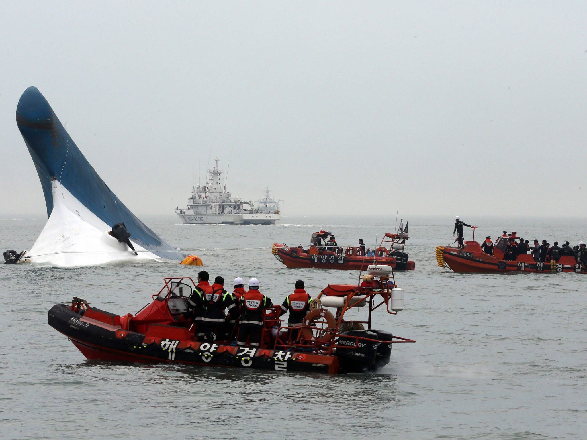 Coast Guard officers conduct a last-minute rescue operation around the passenger ferry Sewol sinking in waters off the southwestern coast of South Korea