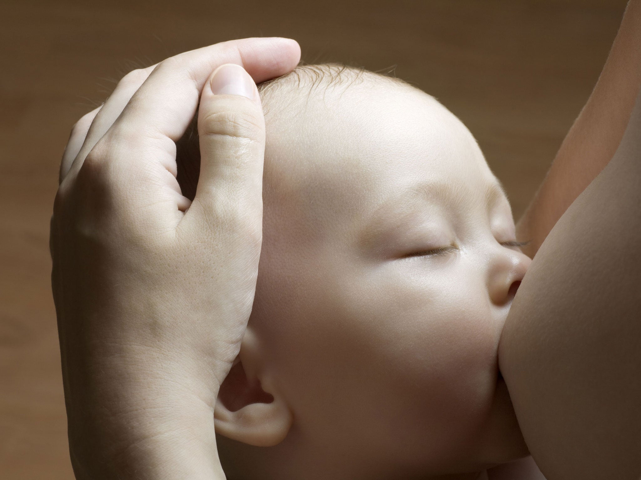 Infant child breast-feeding with eyes closed