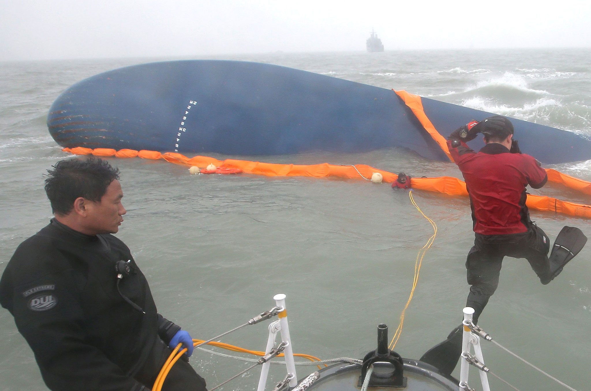 File: Civilian divers jump into the sea to search for missing passengers in the sinking of the ferry Sewol off South Korea's southwestern coast