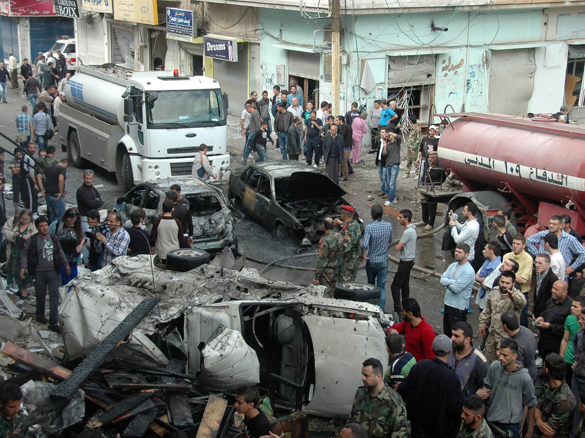 Security and emergency medical personnel work at the site of a car bomb explosion in al-Ushaq street in Ekremah neighboorhood in Syrias central city of Homs