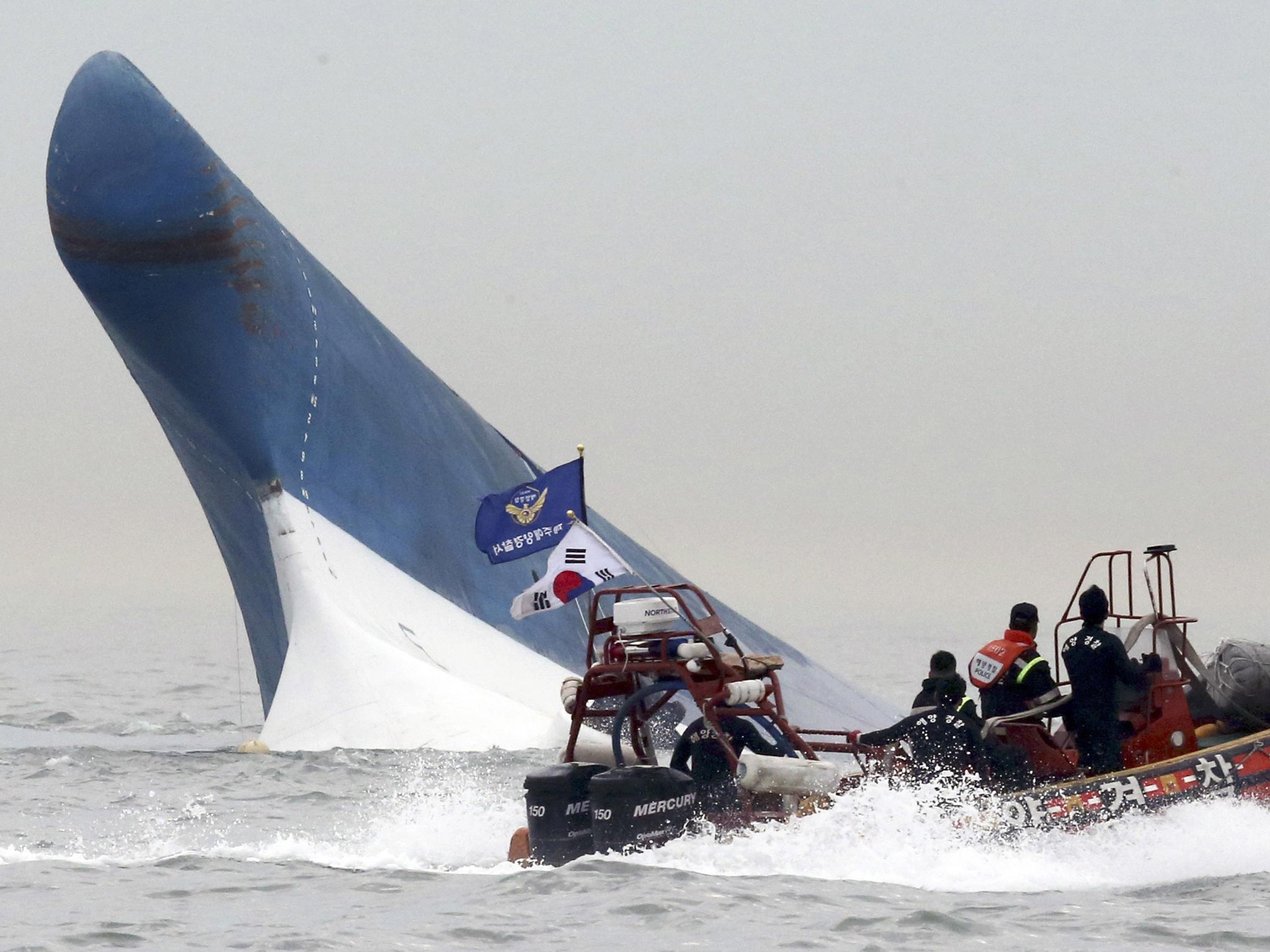 South Korean coast guard officers try to rescue passengers from the Sewol ferry as it sinks in the water off the southern coast near Jindo, south of Seoul, South Korea