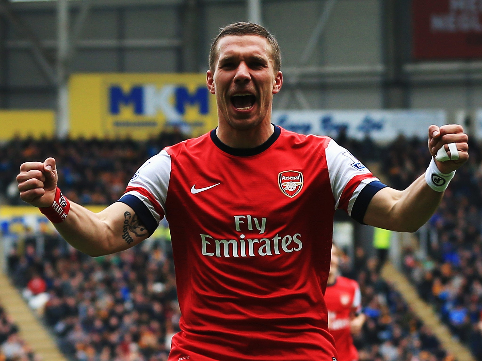 Lukas Podolski celebrates one of his two goals in Arsenal's win over Hull