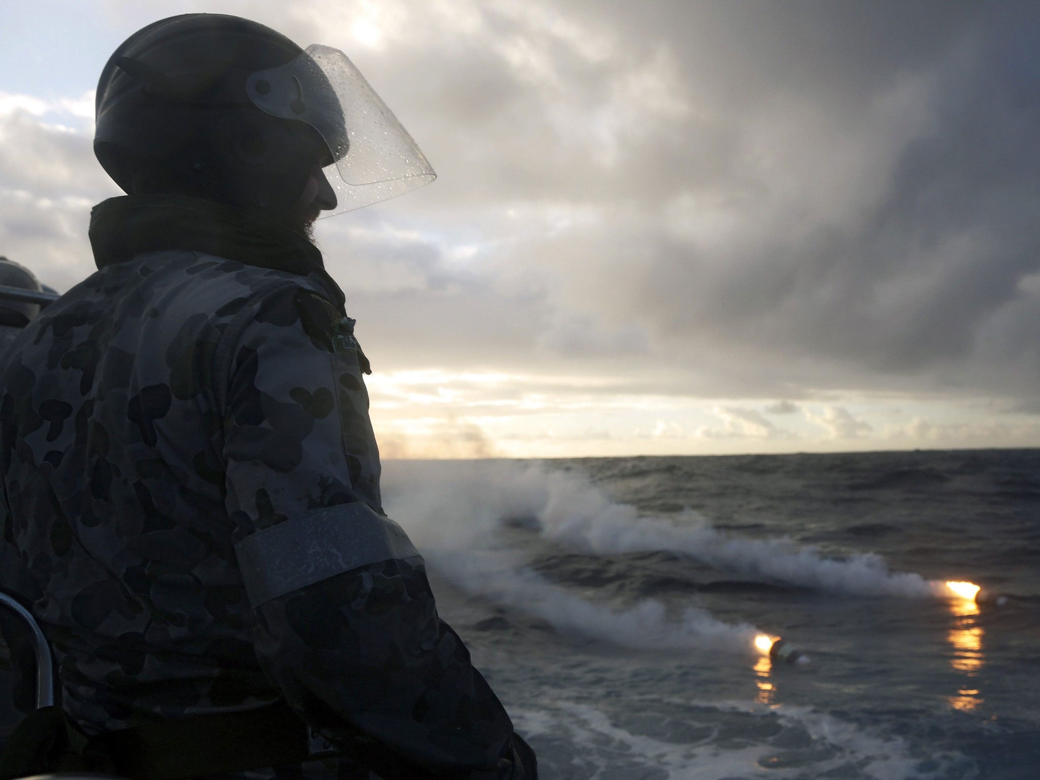 Boatswain's Mate, Able Seaman Morgan Macdonald (L) observing markers from a Royal New Zealand Air Force (RNZAF) P3K Orion at sea in the Southern Indian Ocean