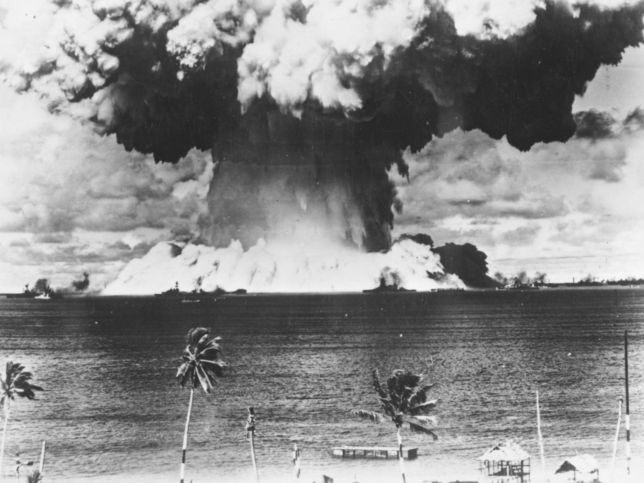 A mushroom cloud rises from the waters of Bikini Lagoon during the United States first series of underwater atomic tests on 7th August 1946 . Ships of a 'Guinea Pig' fleet can be seen against the huge bank of water at the base of the explosion.