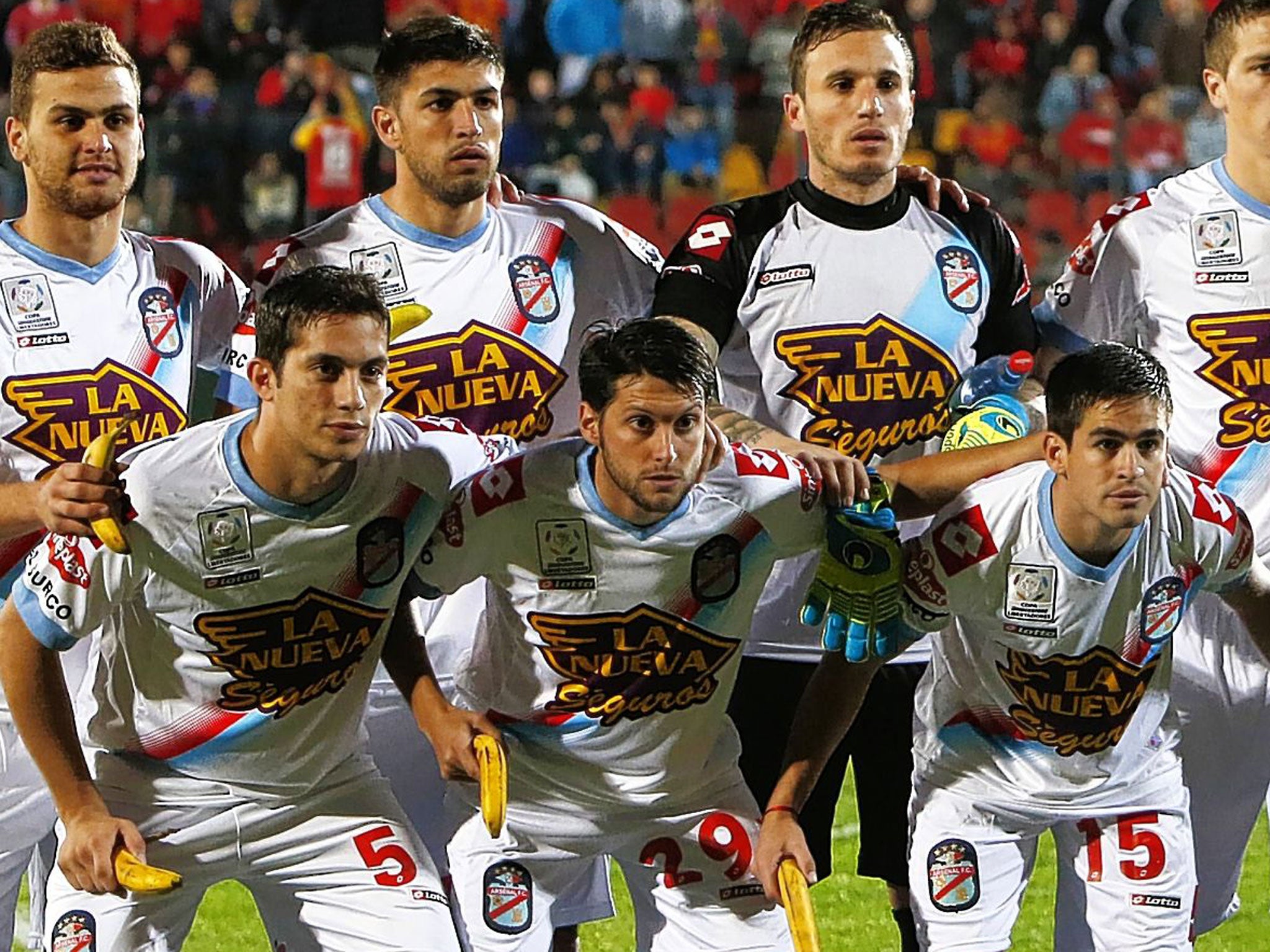 Argentina’s Arsenal team pose holding bananas in Santiago this week as a humorous expression of outrage at the racism aimed at Barcelona’s Dani Alves