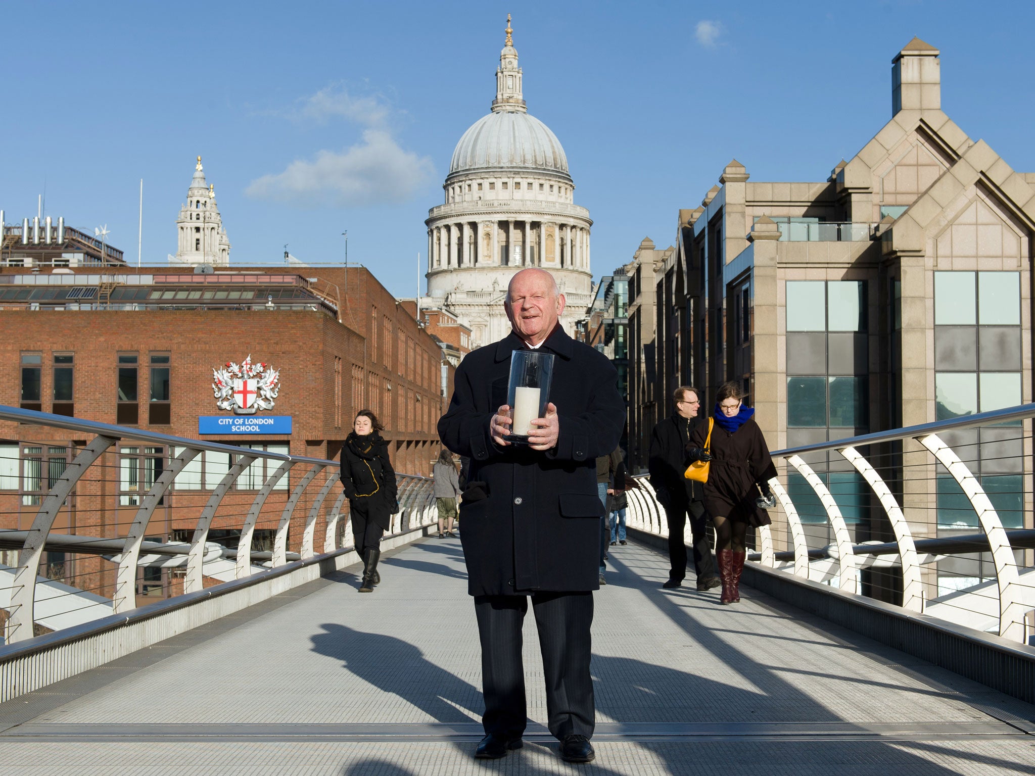 Holocaust survivor Ben Helfgott holds a memorial candle on the Millennium Bridge in London on Holocaust Memorial Day