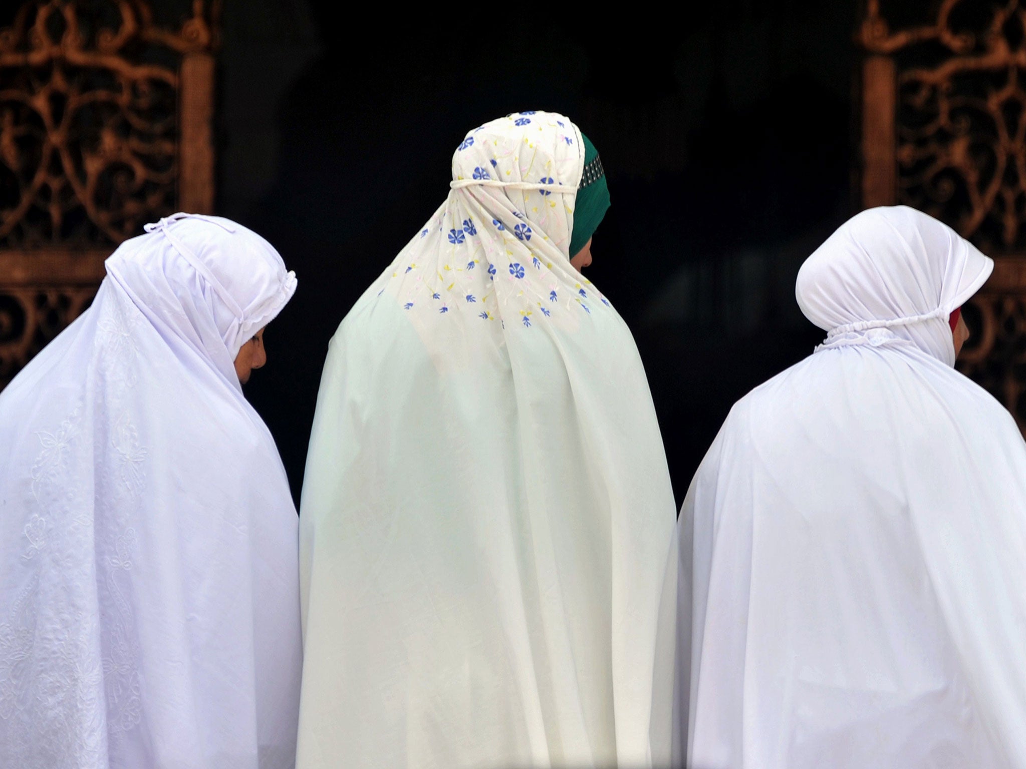 Three Acehnese Muslim women attend Friday prayers at the Baiturrahman great mosque in Banda Aceh