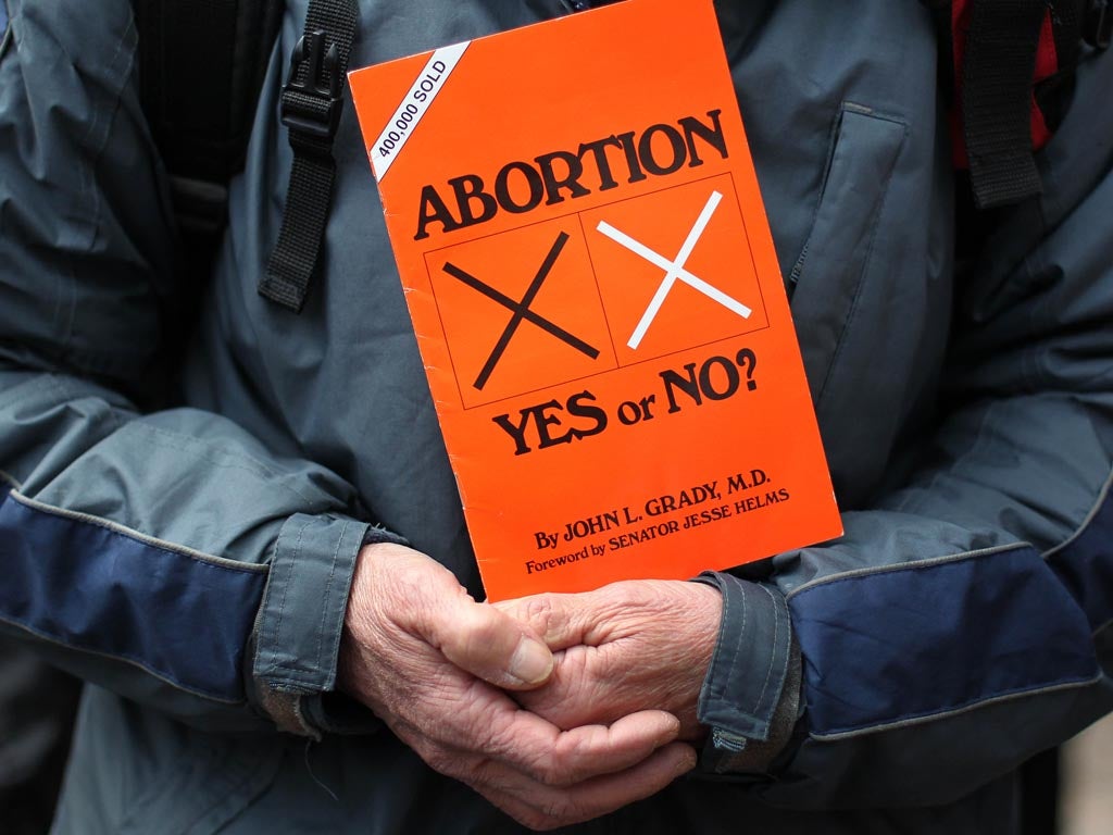 A anti abortion protestors holds up placards outside the Marie Stopes clinic, the first private clinic to offer abortions to women in Belfast, Northern Ireland on October 18, 2012.