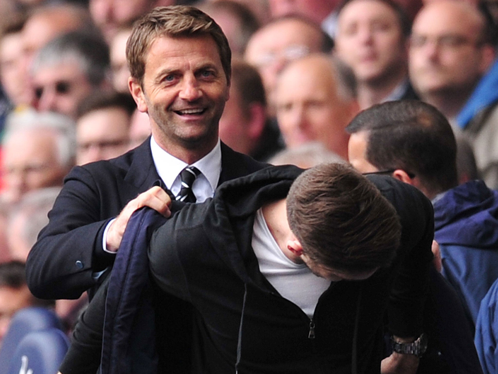 Tim Sherwood has a joke as he helps his jacket onto a fan