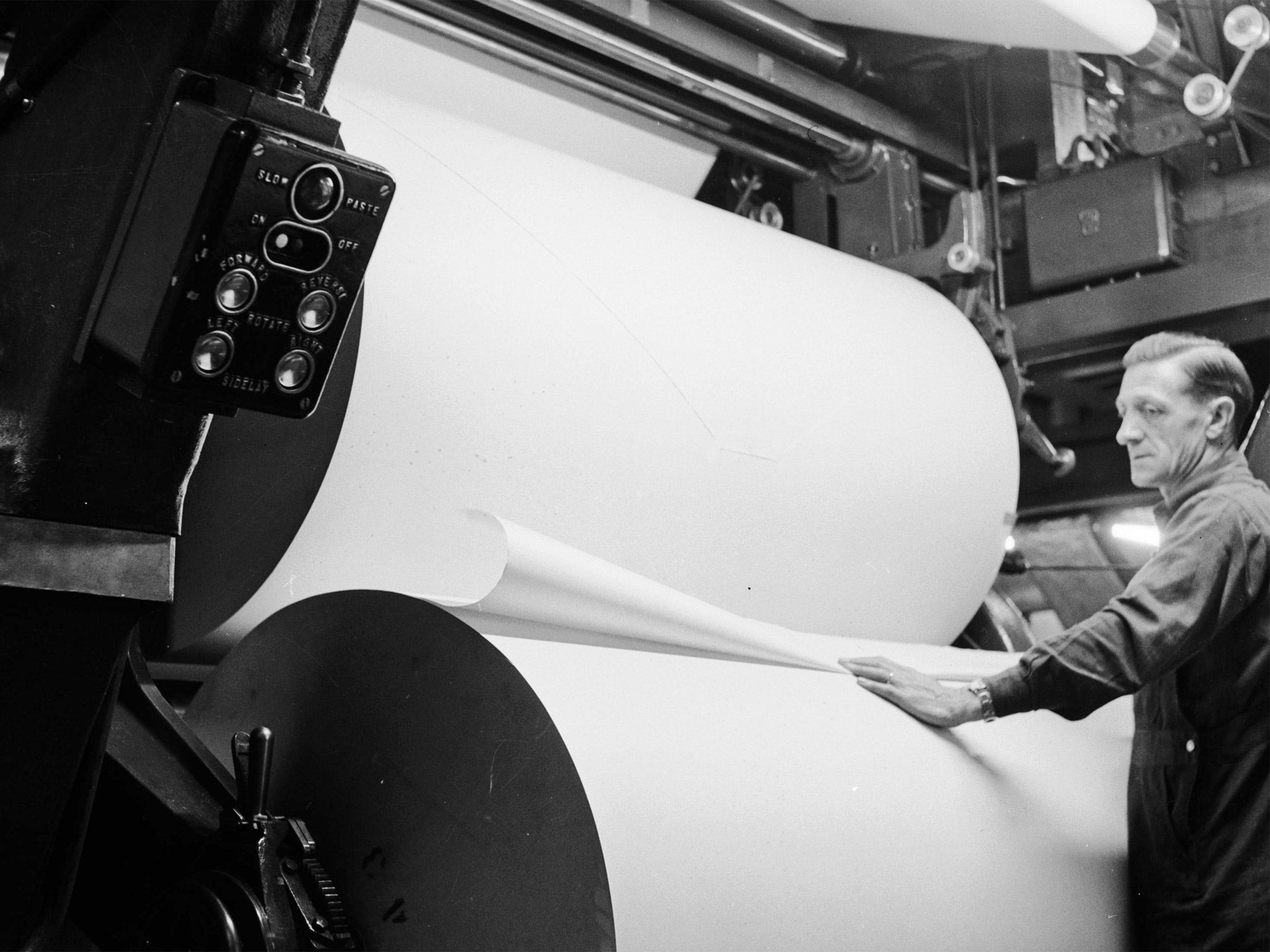 Large rolls of paper are prepared for the printing press at the Daily Express building, Fleet Street, circa 1950 (Getty)