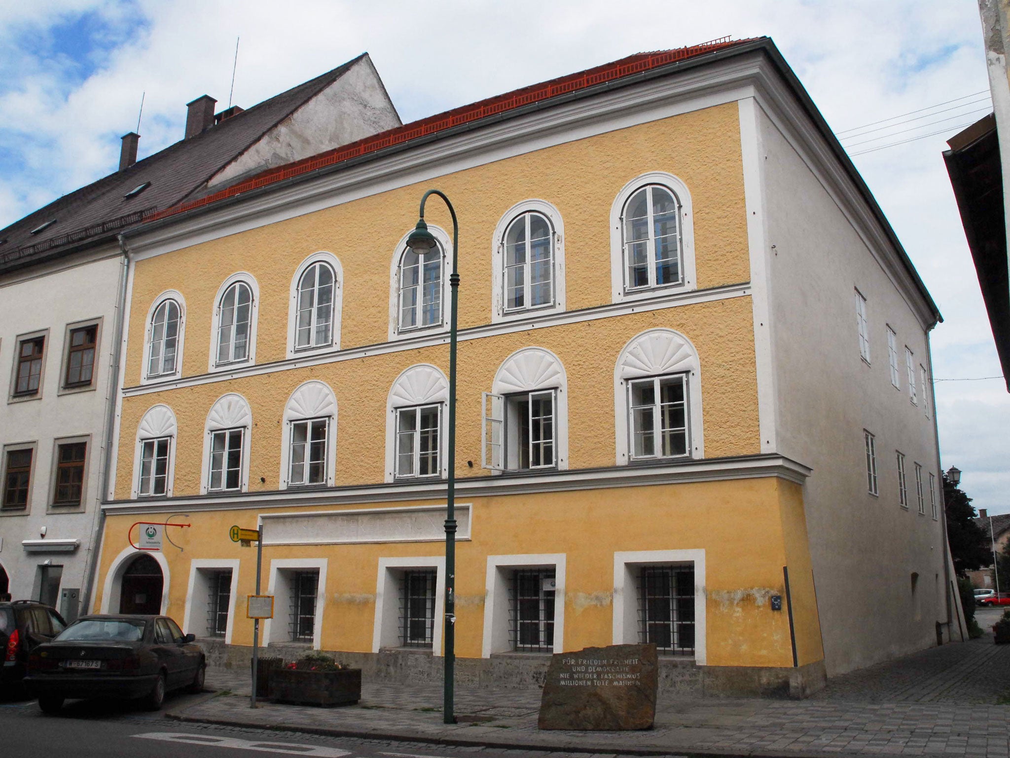 The house where Hitler was born in Braunau am Inn, Austria. A memorial stone in front of the building reads: "For peace, freedom and democracy. Never again fascism. Millions of dead remind [us]"