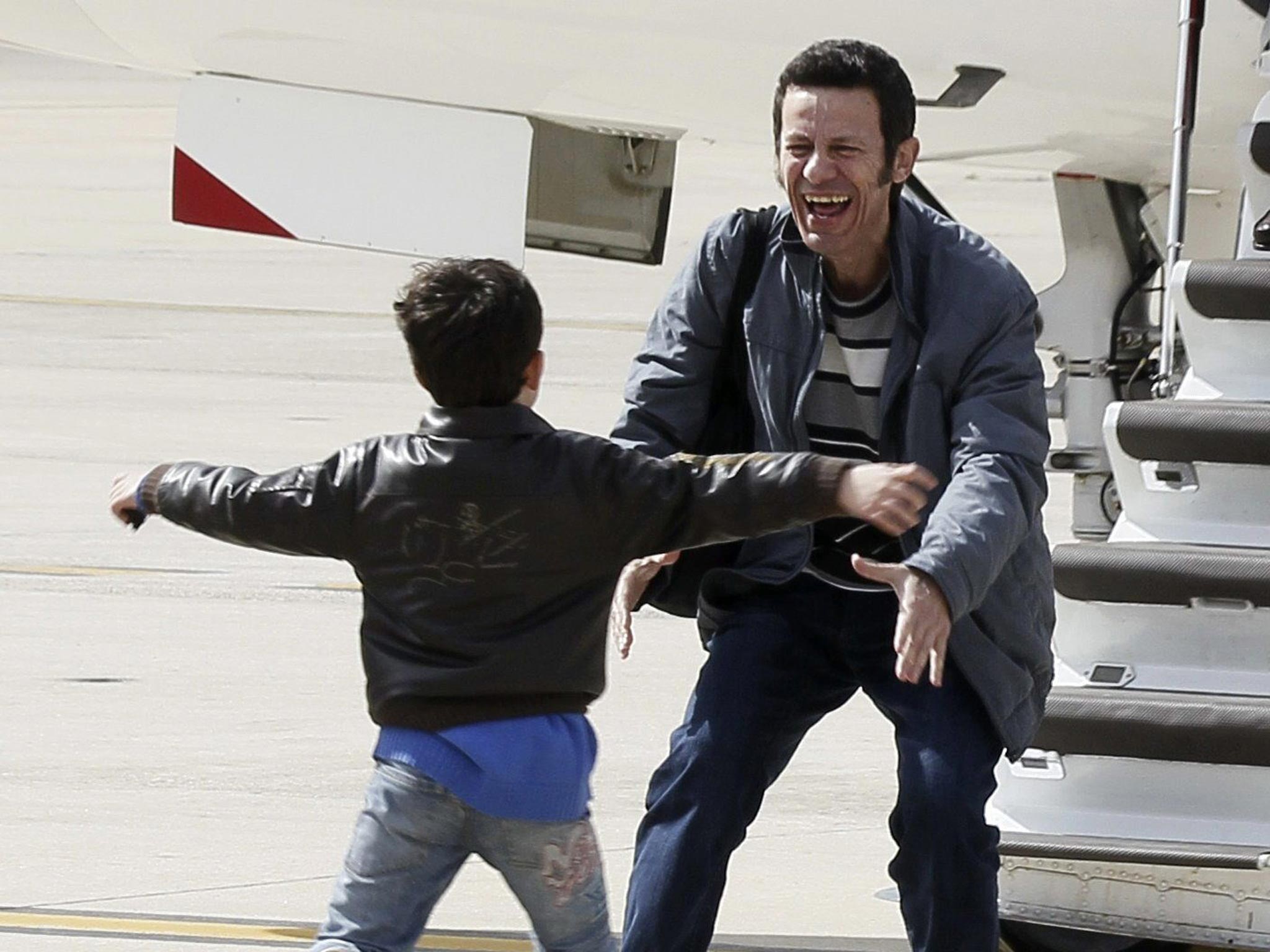 El Mundo correspondent Javier Espinosa is greeted by his son as he arrives at the military airbase in Torrejon de Ardoz, near Madrid