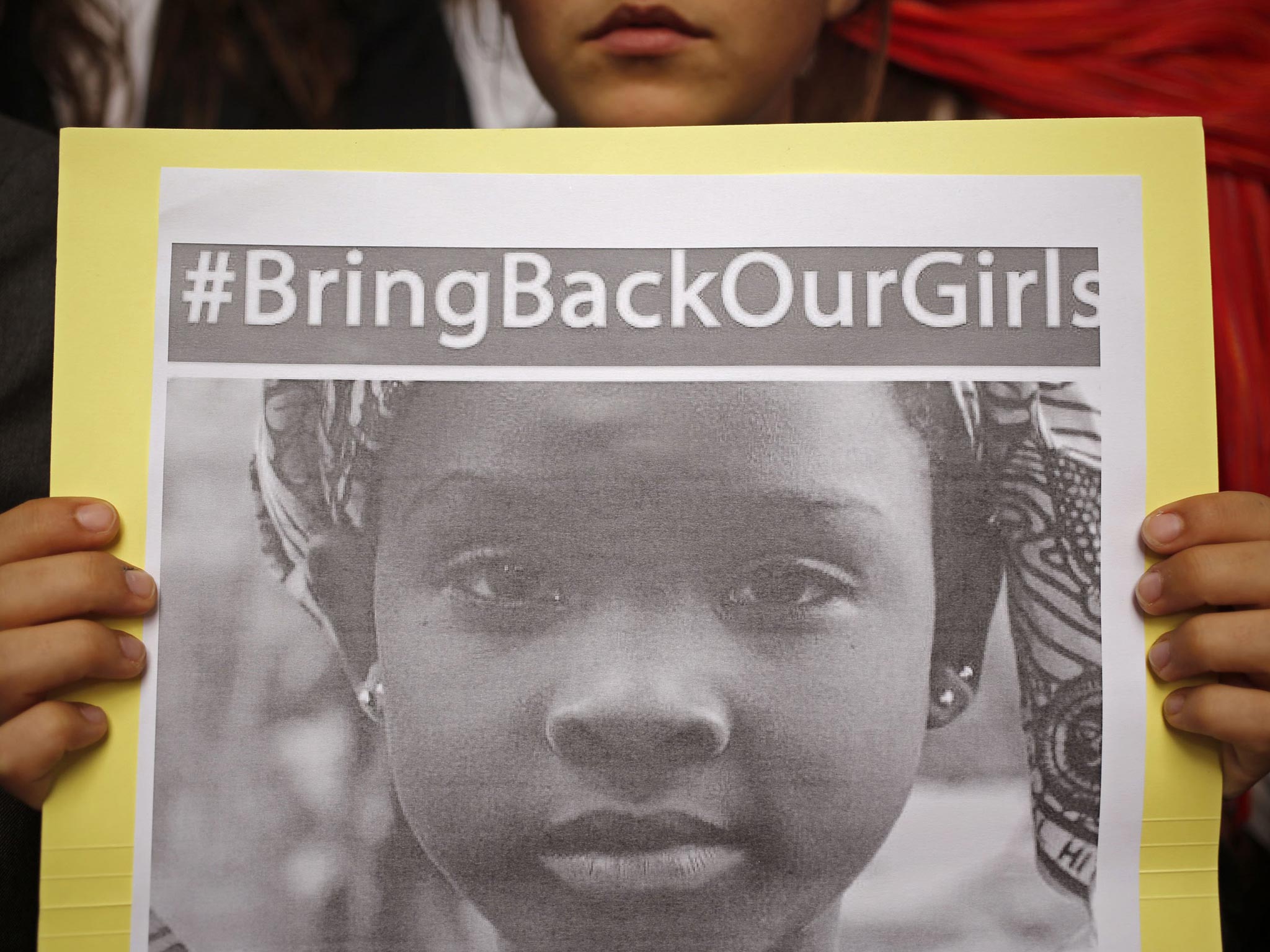 A South African school girl, displays a poster as she and other children and religious leaders take part in a silent protest