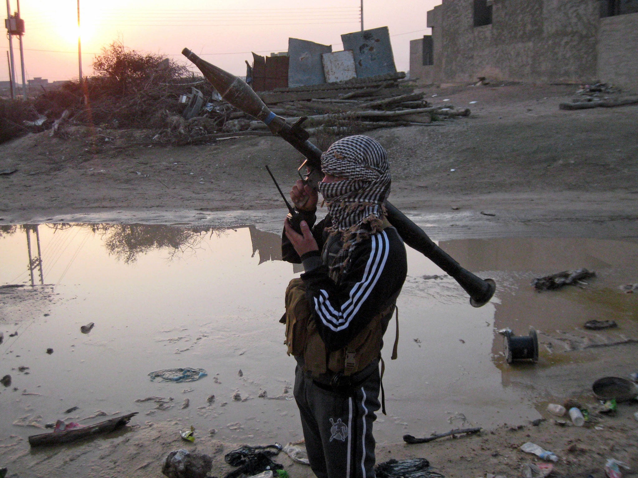 A gunman makes a radio call in rebel-held Fallujah, just west of Baghdad in Iraq. Government forces face difficulties fighting their way into the city against the entrenched resistance