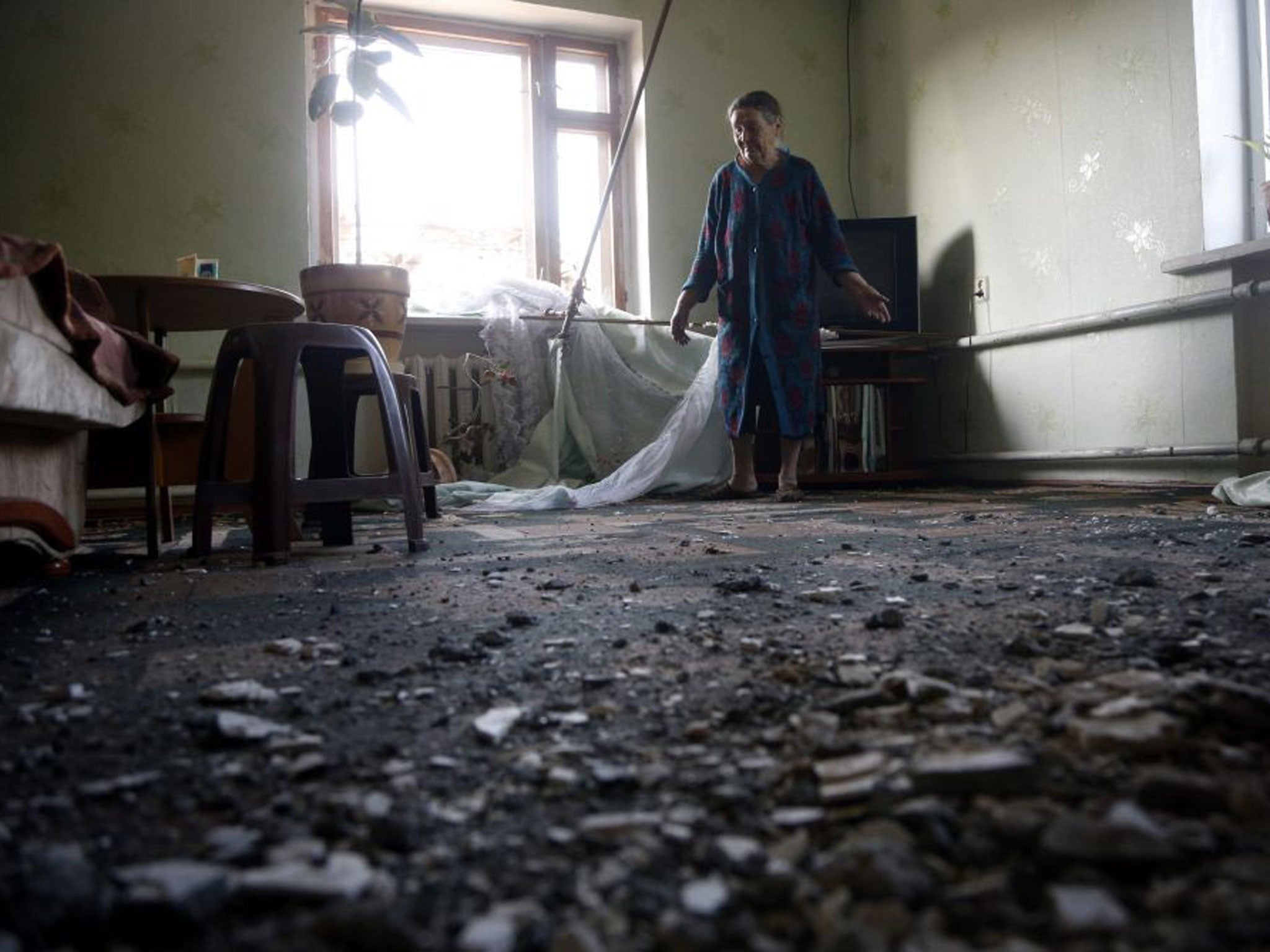 Roza Gerasimenko, 69, is overcome with emotion assessing the damage to her house from shell explosions during the fighting between pro-Russian militants and the Ukrainian army in Slovyansk