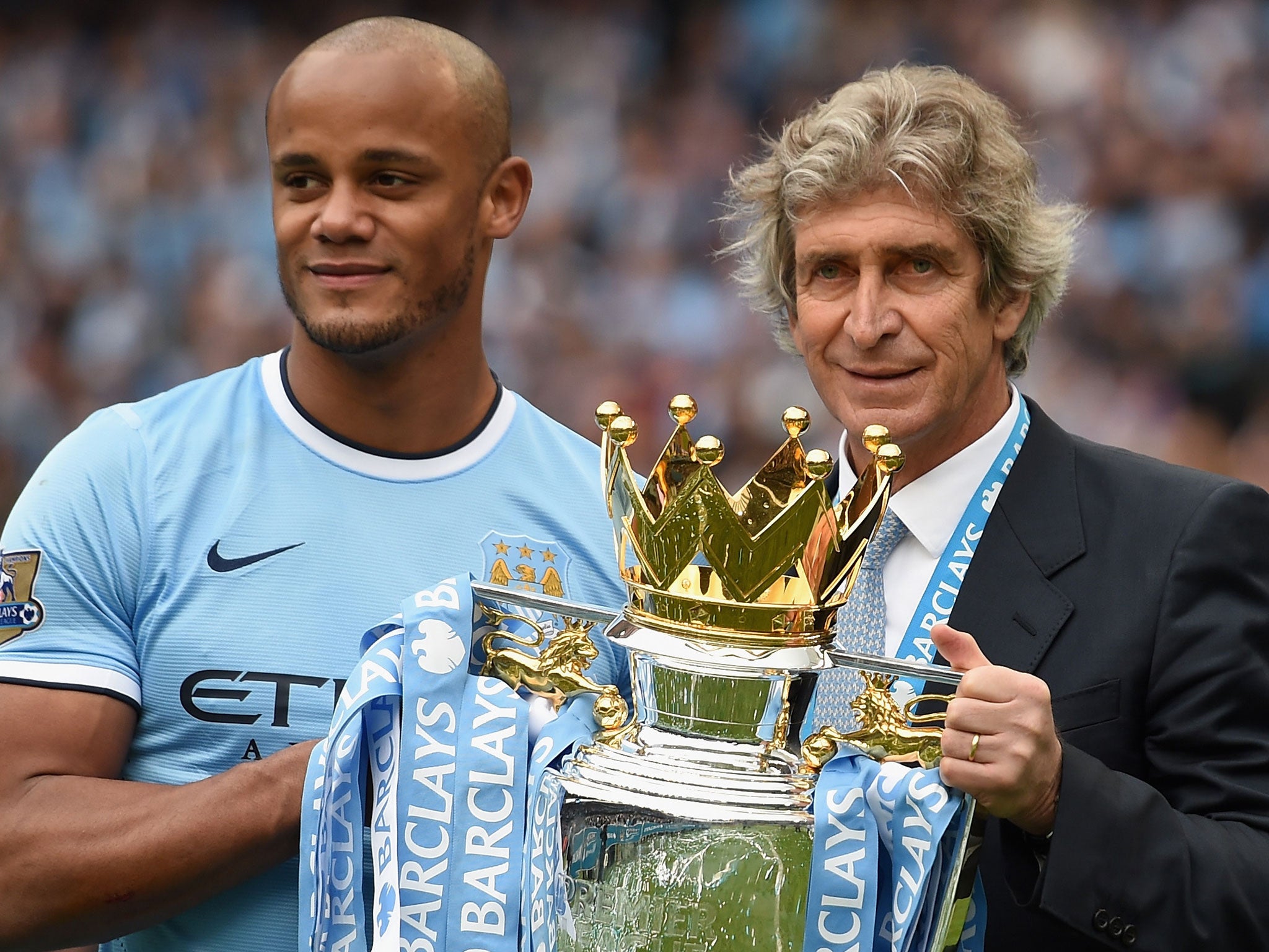 Vincent Kompany and Manuel Pellegrini celebrate winning last season's Premier League trophy