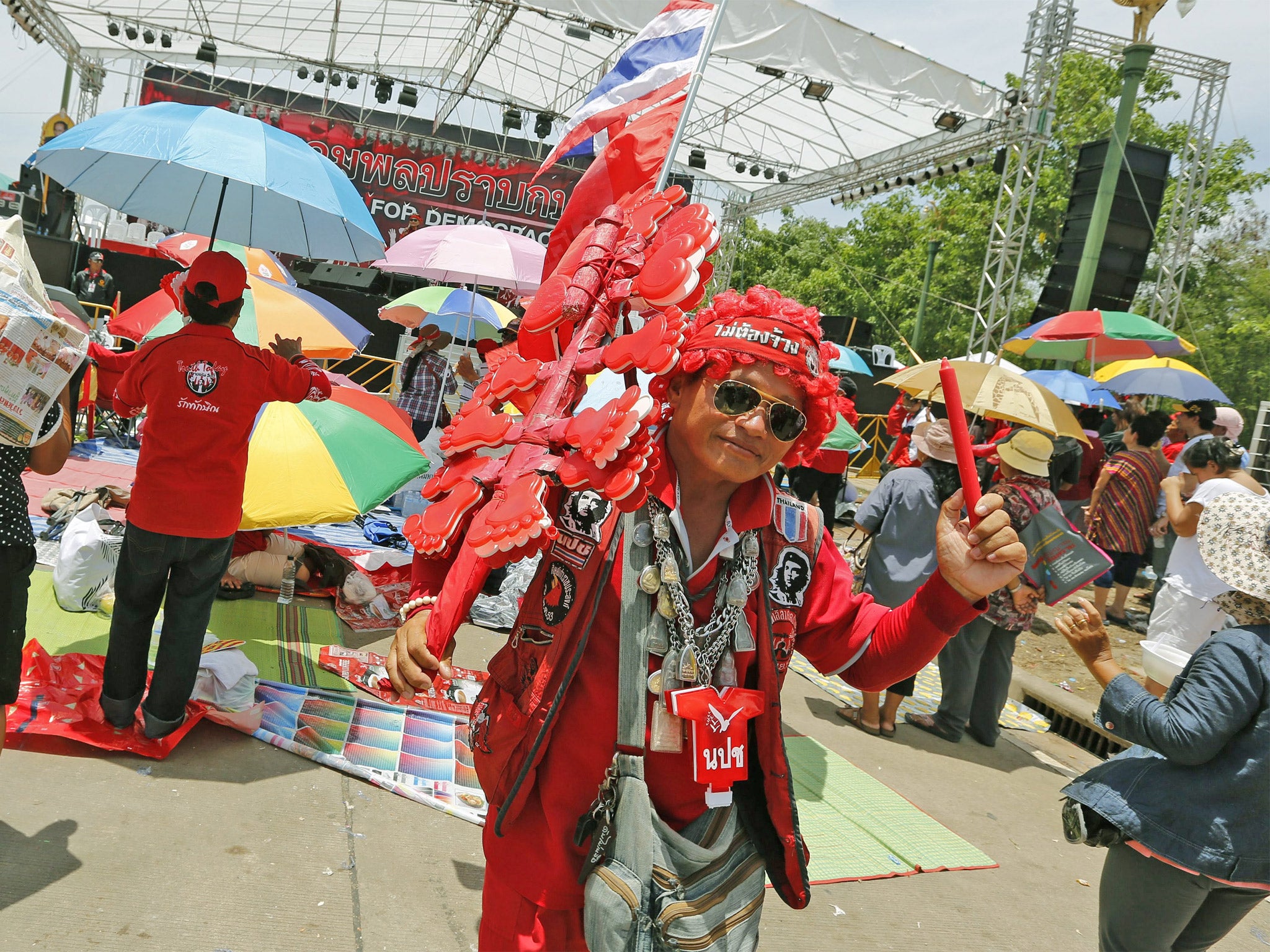 A Thai pro-government Red Shirts protester shakes clapper during a rally on the outskirts of Bangkok