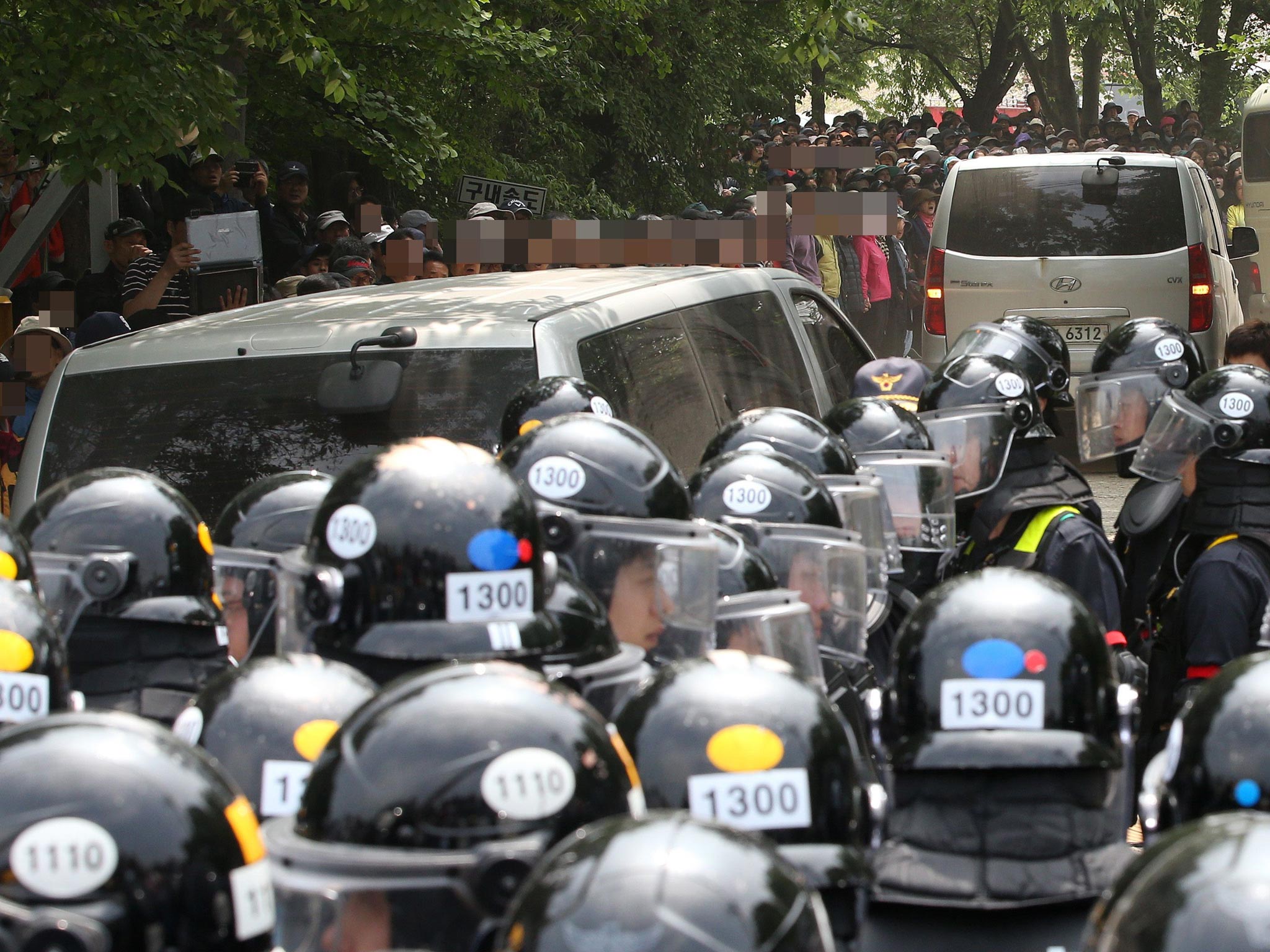 A convoy carrying investigators struggles through police lines to enter the sprawling church compound of Yoo Byung-Eun in Anseong, south of Seoul