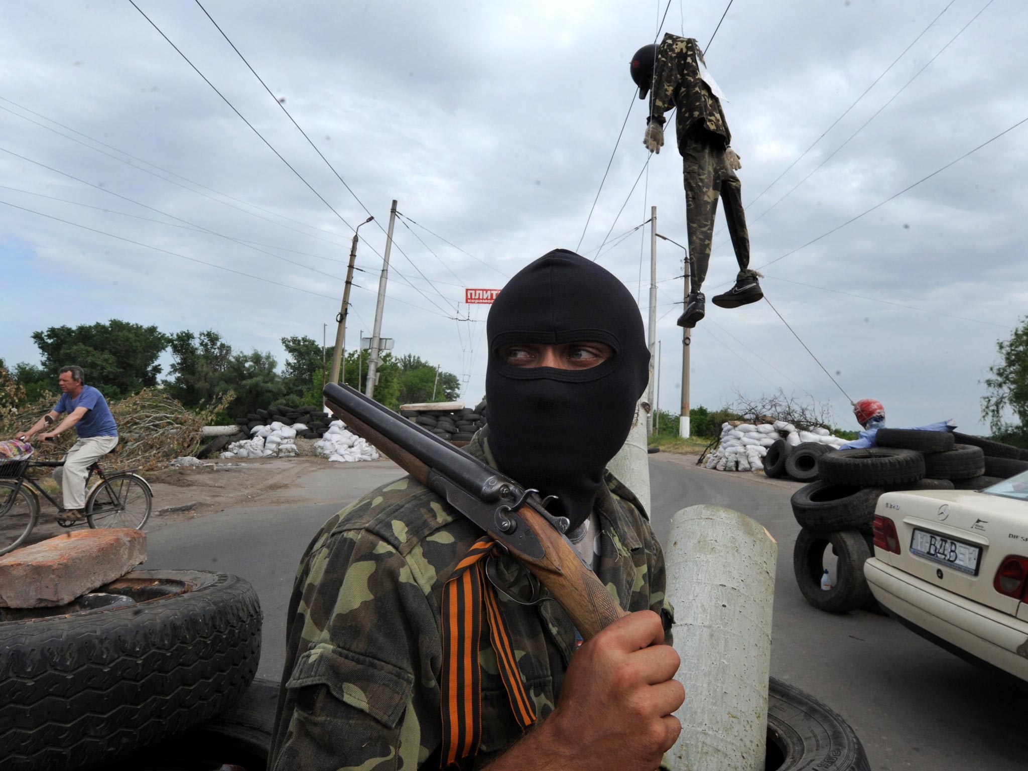 A masked pro-Russian gunman guards at a check-point near the eastern Ukrainian city of Slavyansk on Friday. At least five were killed yesterday in fighting near Ukraine’s eastern hub of Donetsk