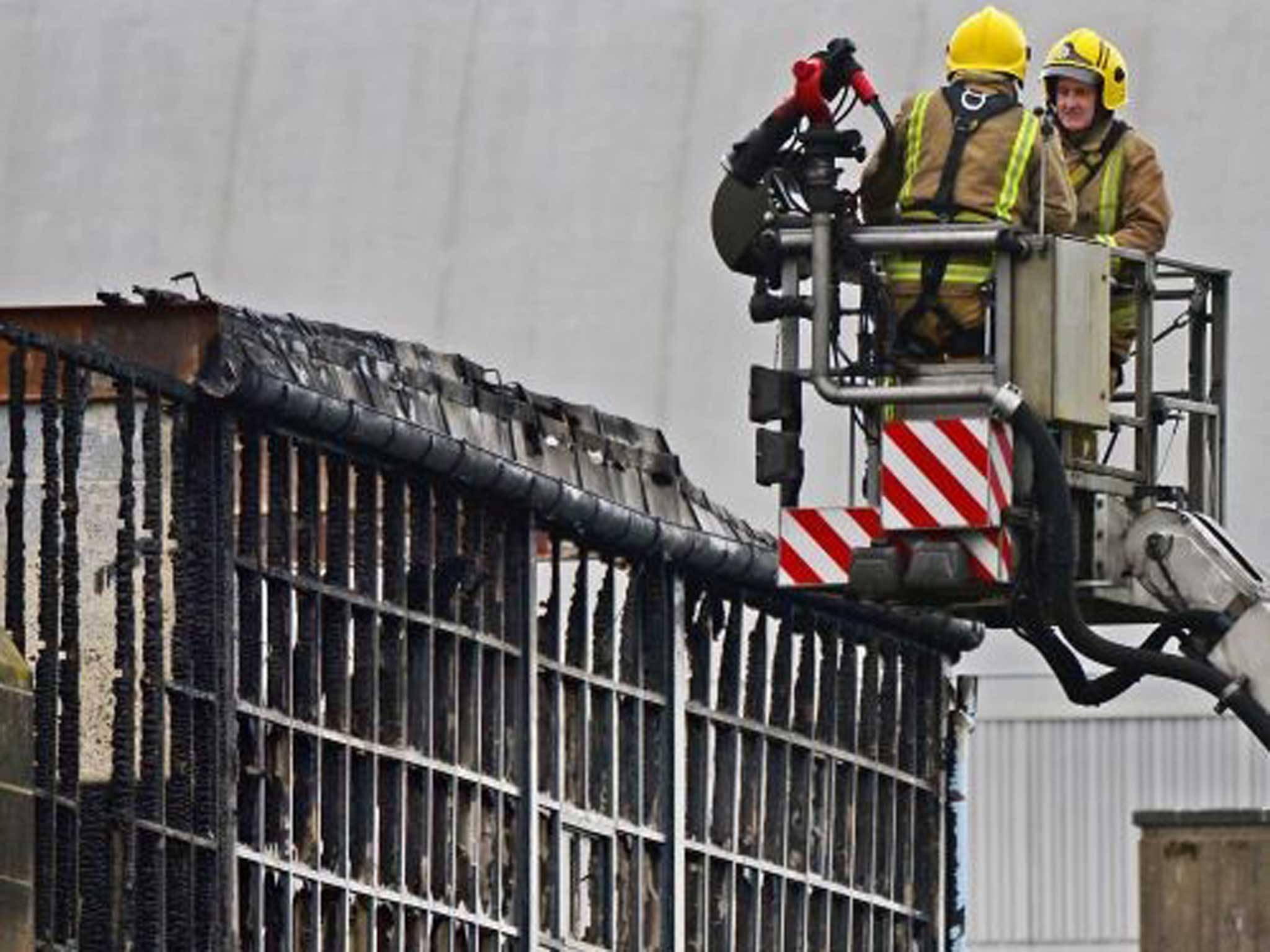 Firefighters survey the wreckage after the fire