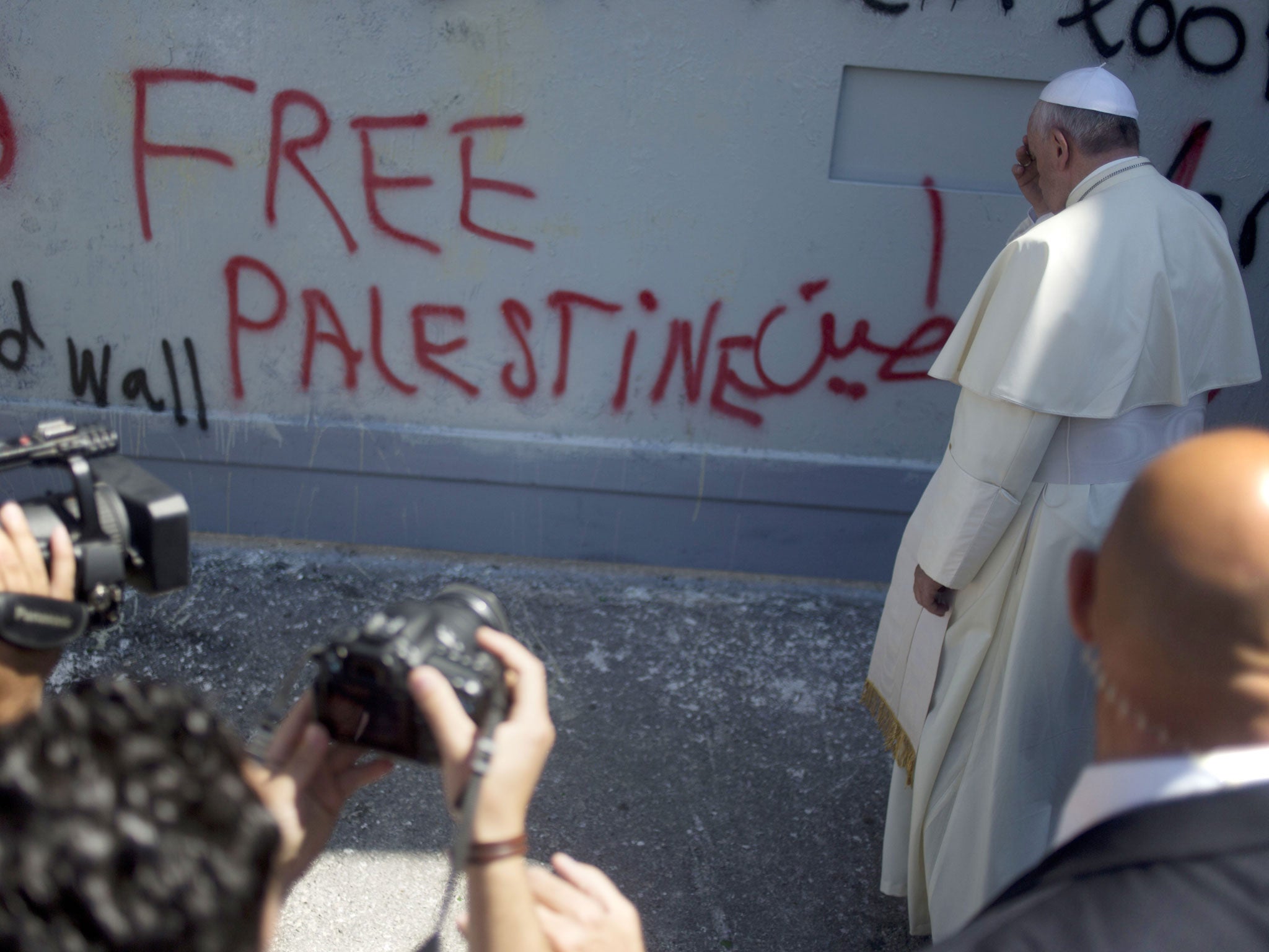 Pope Francis prays at Israel's separation barrier on his way to a mass in Manger Square next to the Church of the Nativity, traditionally believed to be the birthplace of Jesus Christ