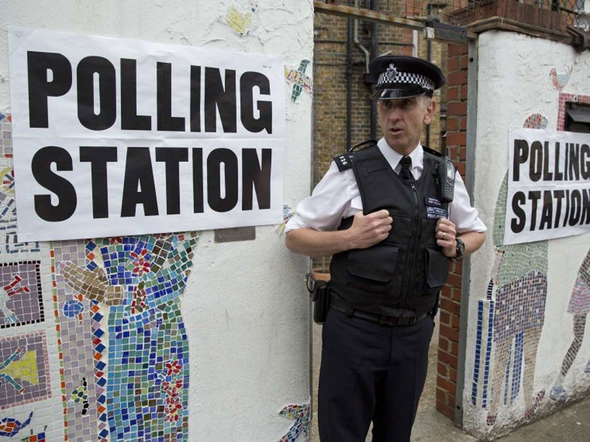 A police officer stands outside a polling station in Tower Hamlets