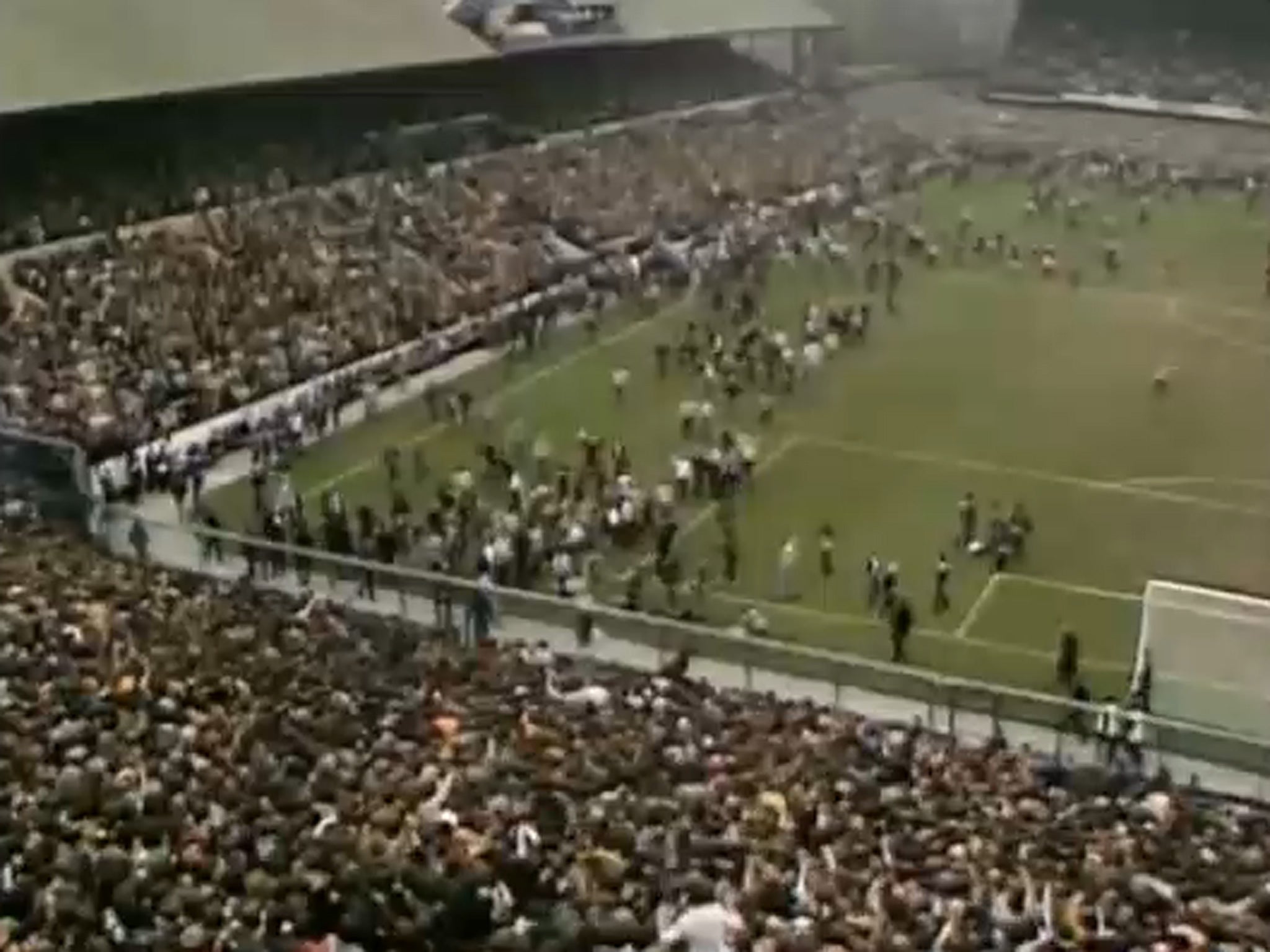 Crowds run across the pitch during the match