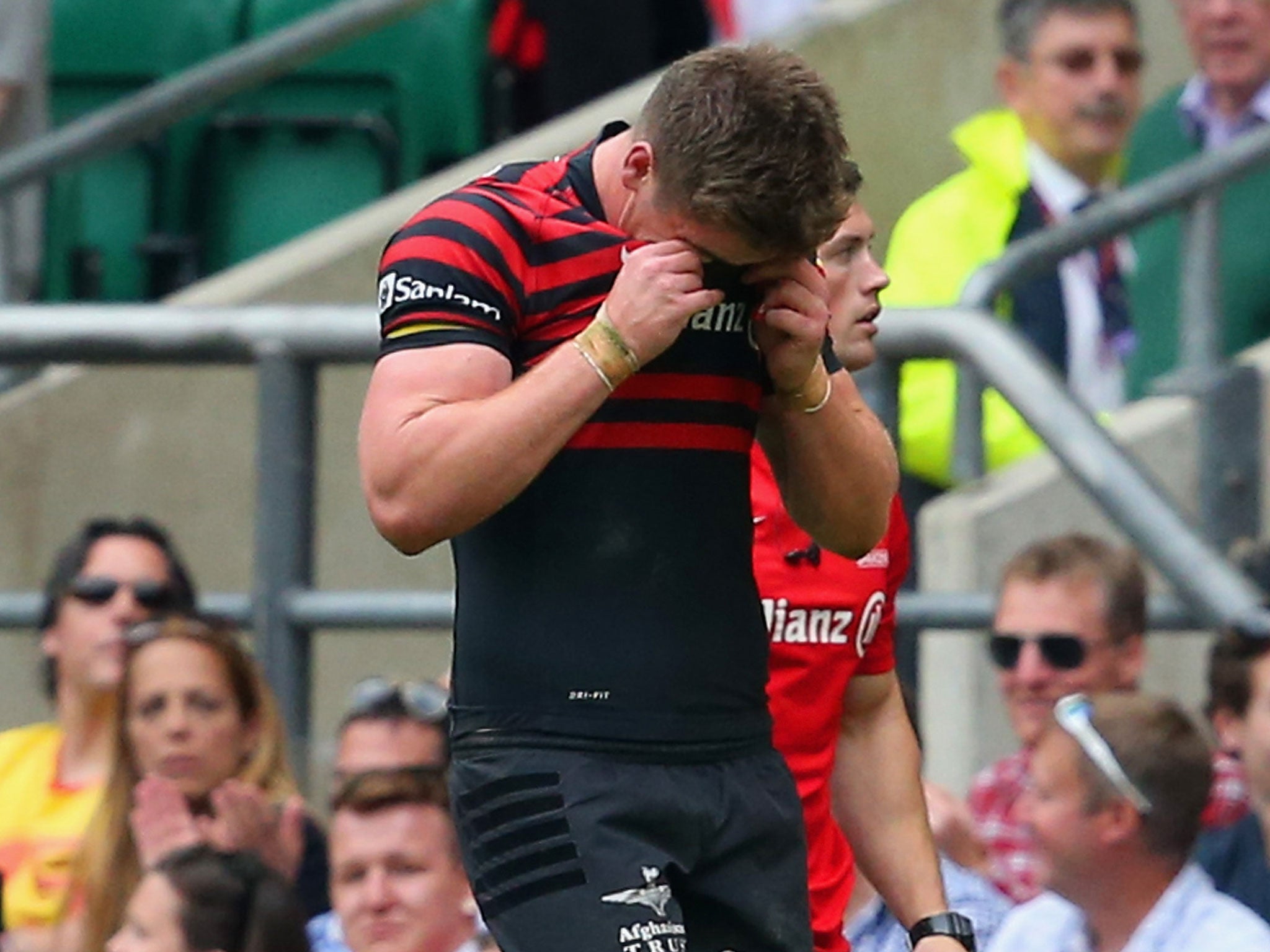 Owen Farrell of Saracens wipes his face as he leaves field during the Aviva Premiership Final between Saracens and Northampton Saints at Twickenham