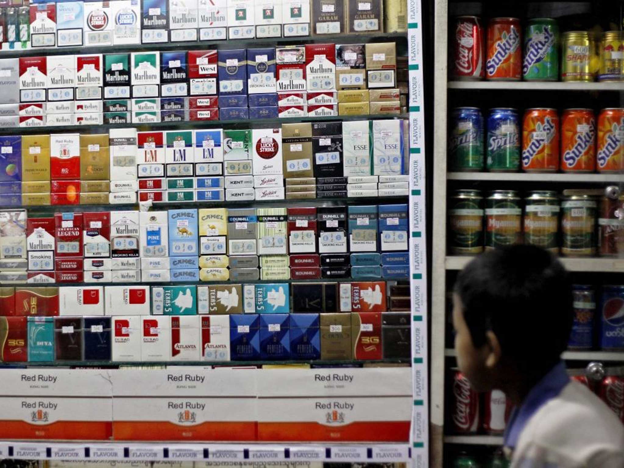 A small boy looks over the counter at the cigarettes available in Asia