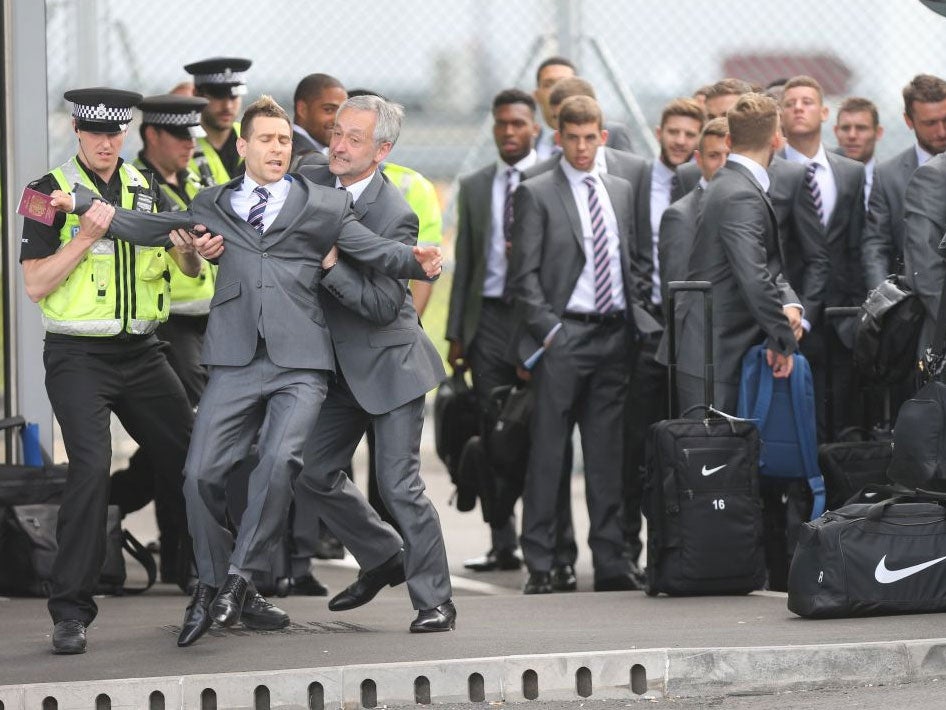 Comedian Simon Brodkin being taken away by police after getting past security and talking to the England team