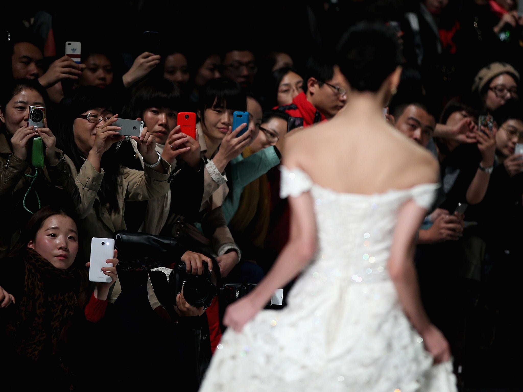 Visitors take pictures with smart phones during Mercedes-Benz China Fashion Week spring/summer2014