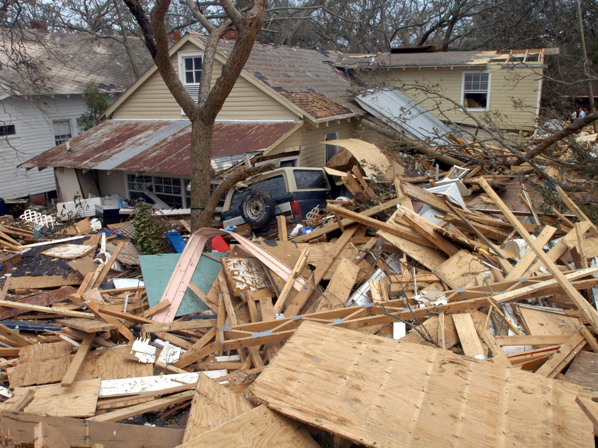 A SUV lies against a house and rubble in Biloxi, Mississippi as Hurricane Katrina hit USA, 2005