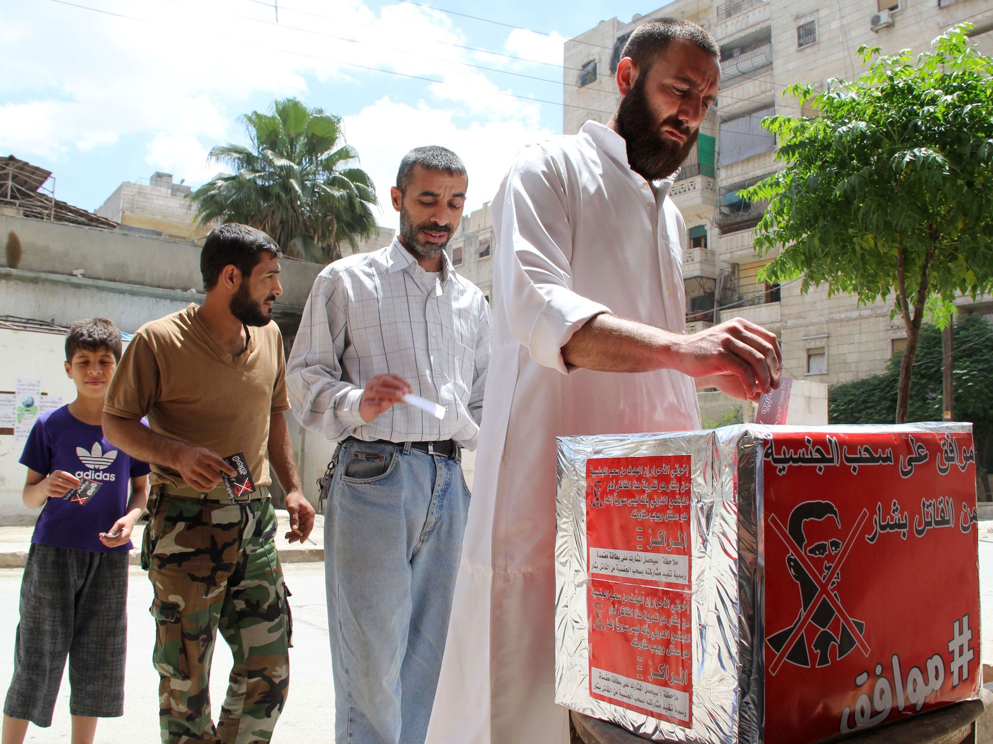 Syrian men pretend they are casting their votes during a mock election calling for the "criminal" Syrian President Bashar al-Assad to the stripped of his Syrian nationality in the mostly rebel-held city of Aleppo