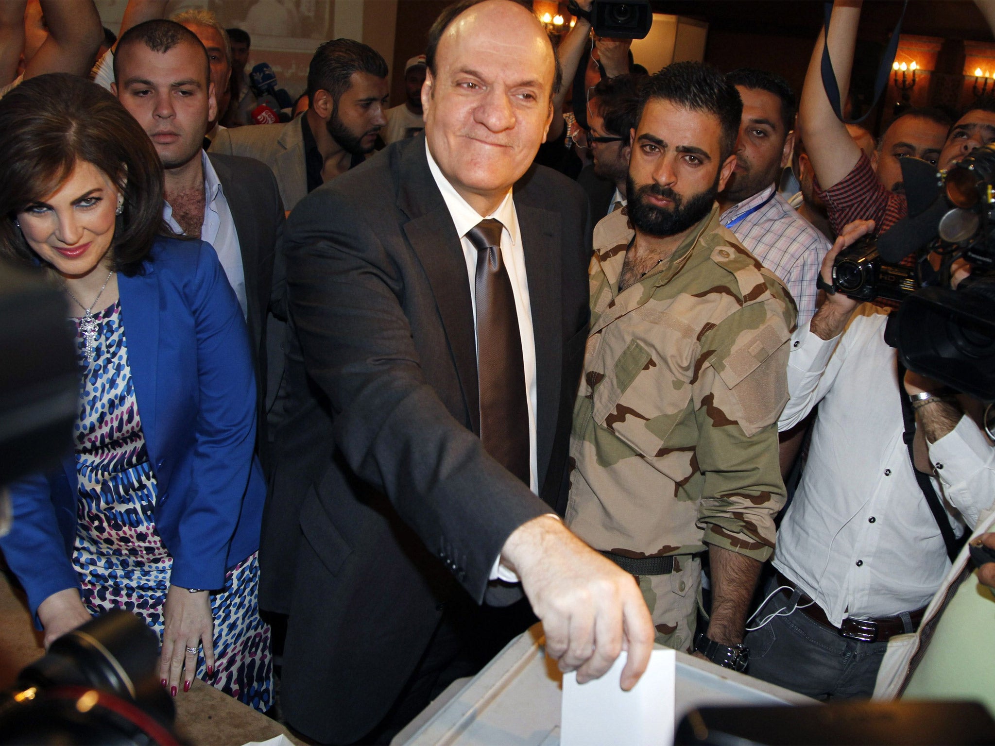 Syria’s presidential candidate Hassan al-Nouri accompanied by his wife Hazar casts his vote at polling centre in Damascus (Getty)