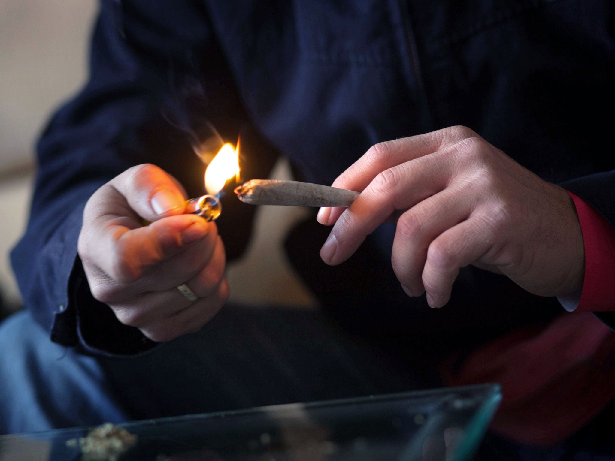 A persons lights a joint of cannabis during a meeting of members and guests of the cannabis association ACMEFUR in celebration of San Canuto's day on the Spanish Canary island of Fuerteventura on January 18, 2014. In Spain, Canute IV or Canute the Holy a