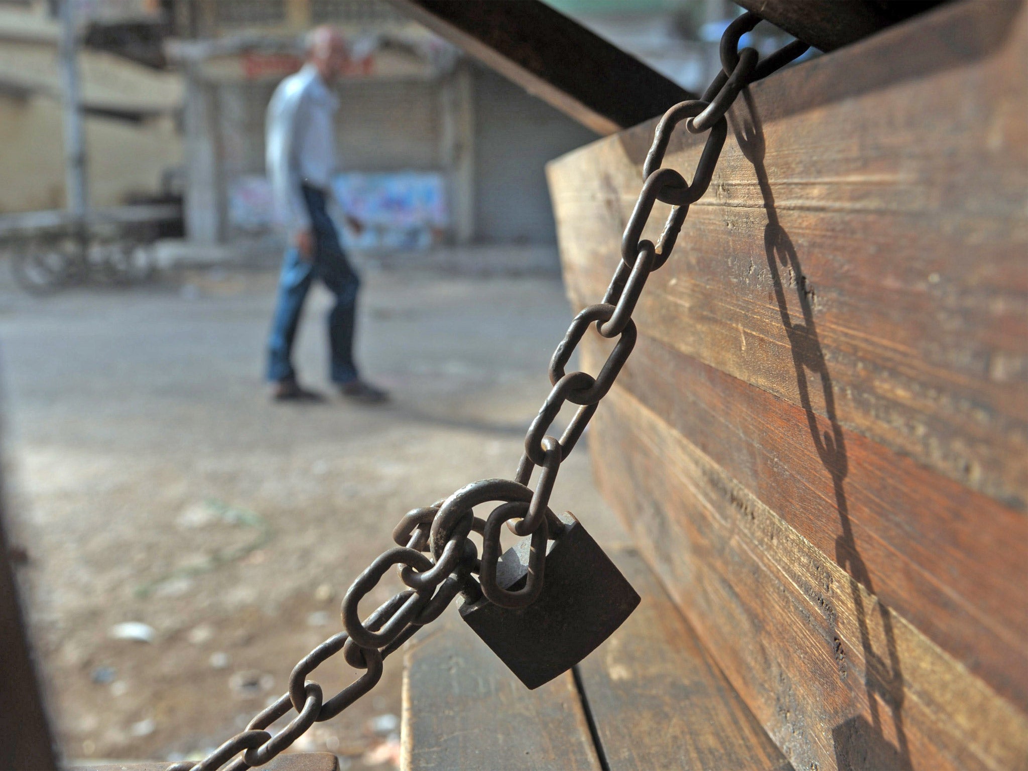 A Pakistani walks past a closed market in Karachi (Getty)