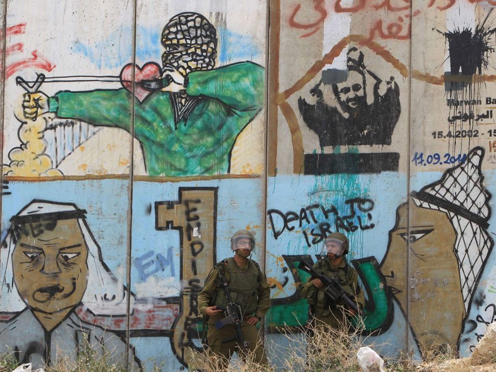 Members of the Israeli security forces stand guard at a Palestinian protest in front of Israel's controversial separation barrier