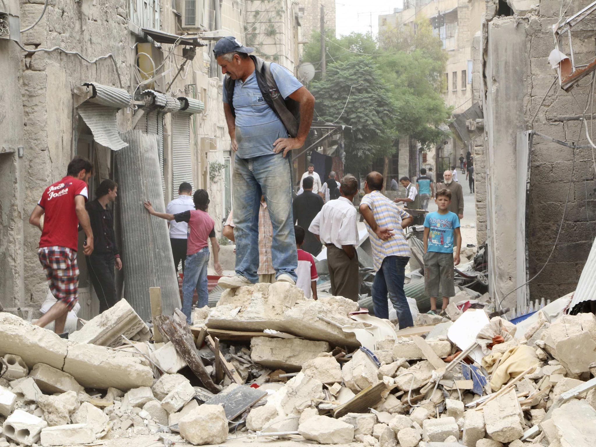 People inspect a site hit by what activists said was a barrel bomb dropped yesterday evening (AP)