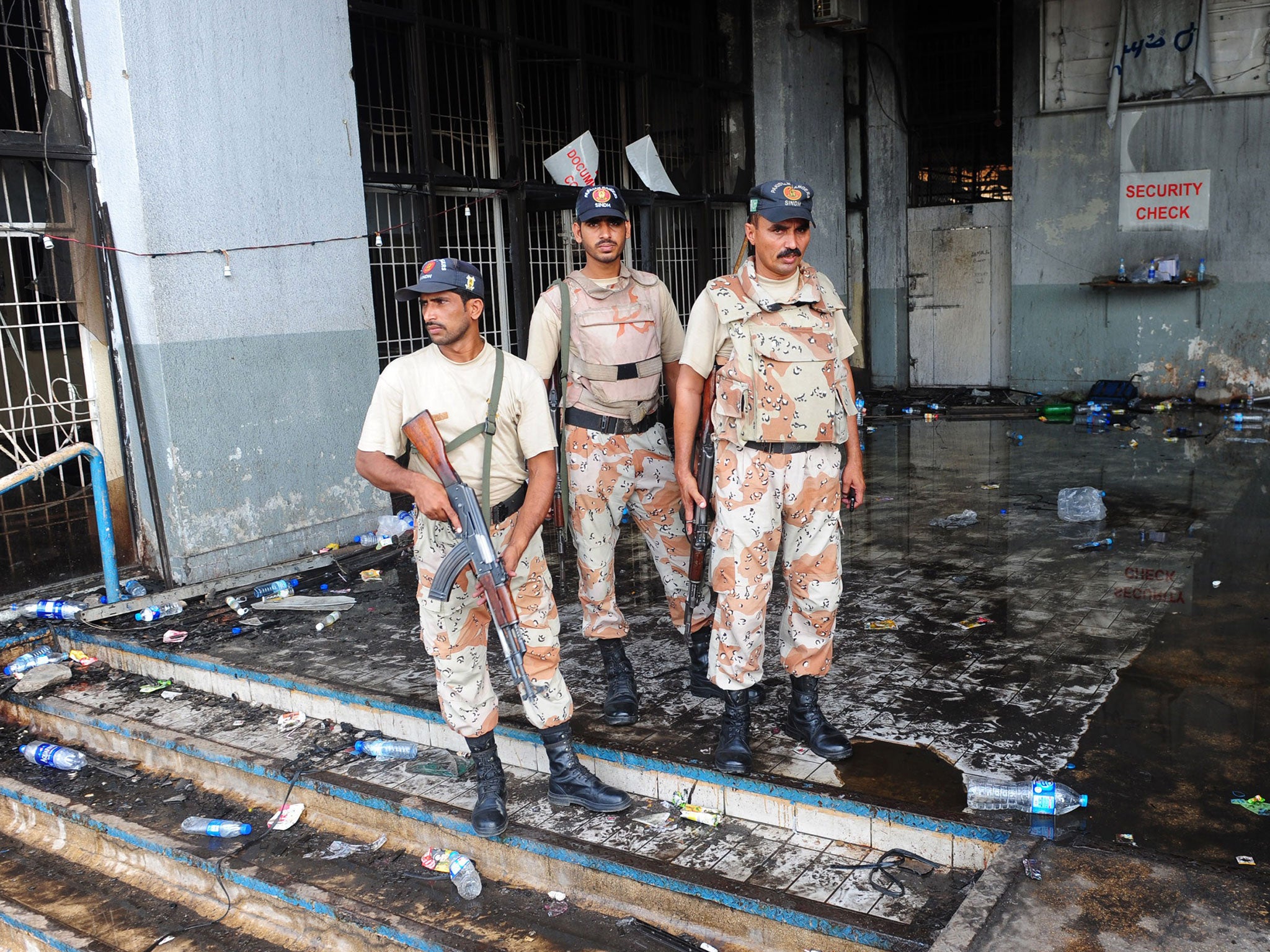 Pakistani Rangers keep watch at the fire-damaged premises of a cold-storage cargo facility at the Jinnah International Airport in Karachi on 10 June 2014, following the 9 June attack by militants