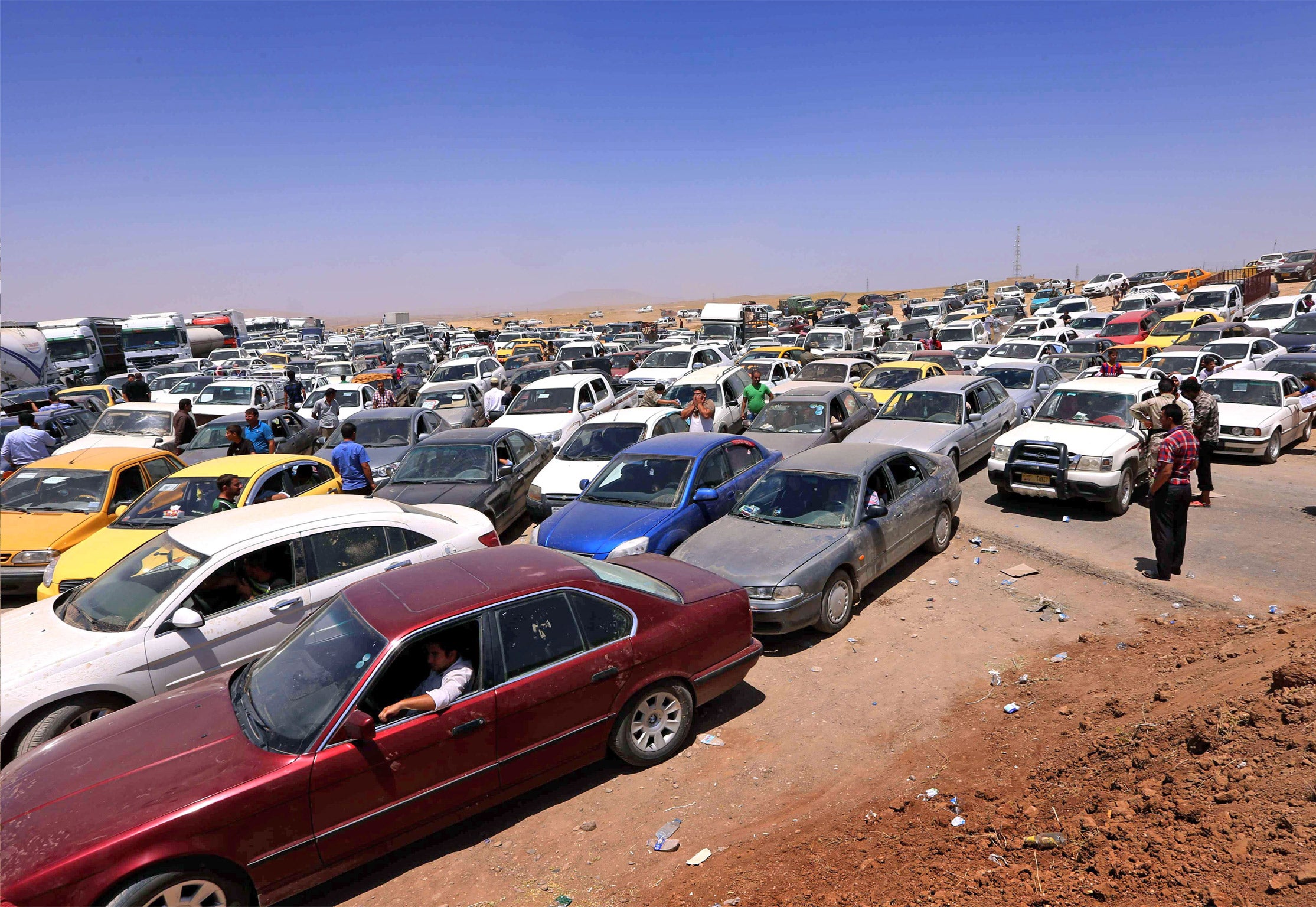 Iraqis fleeing violence in Mosul wait in their vehicles at a Kurdish checkpoint (Getty)